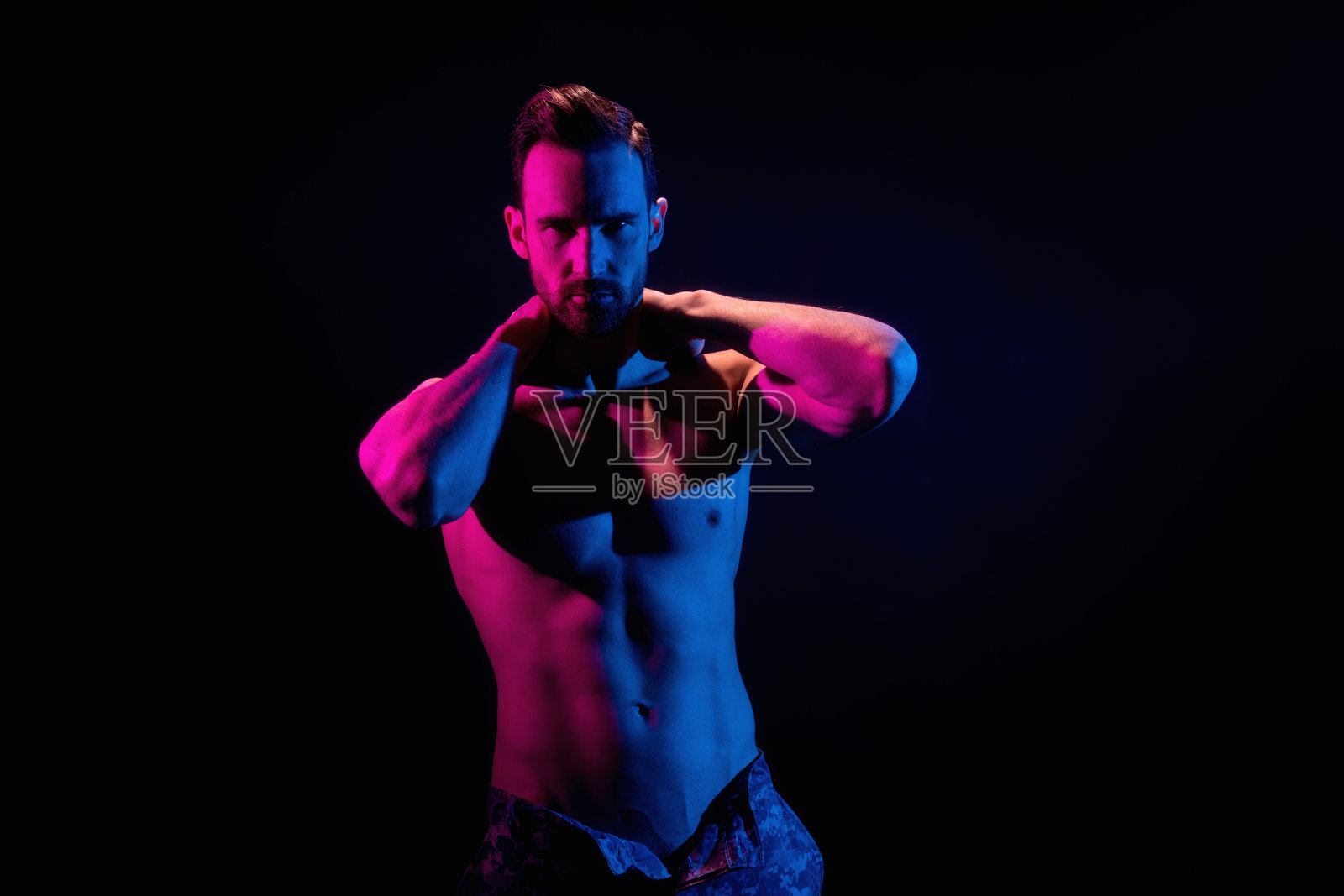 英俊的男子在黑色背景与红色和蓝色照明照片摄影图片