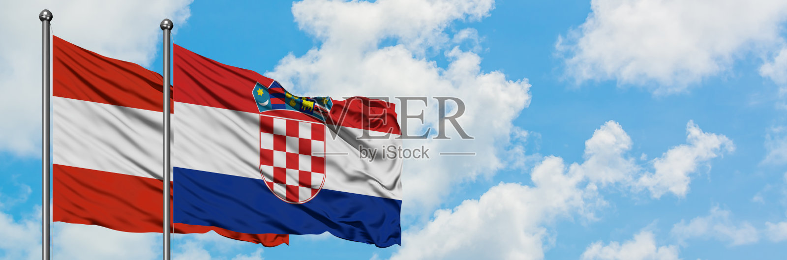 奥地利和克罗地亚的国旗一起在风中飘扬，对抗着白色多云的蓝天。外交理念，国际关系。照片摄影图片