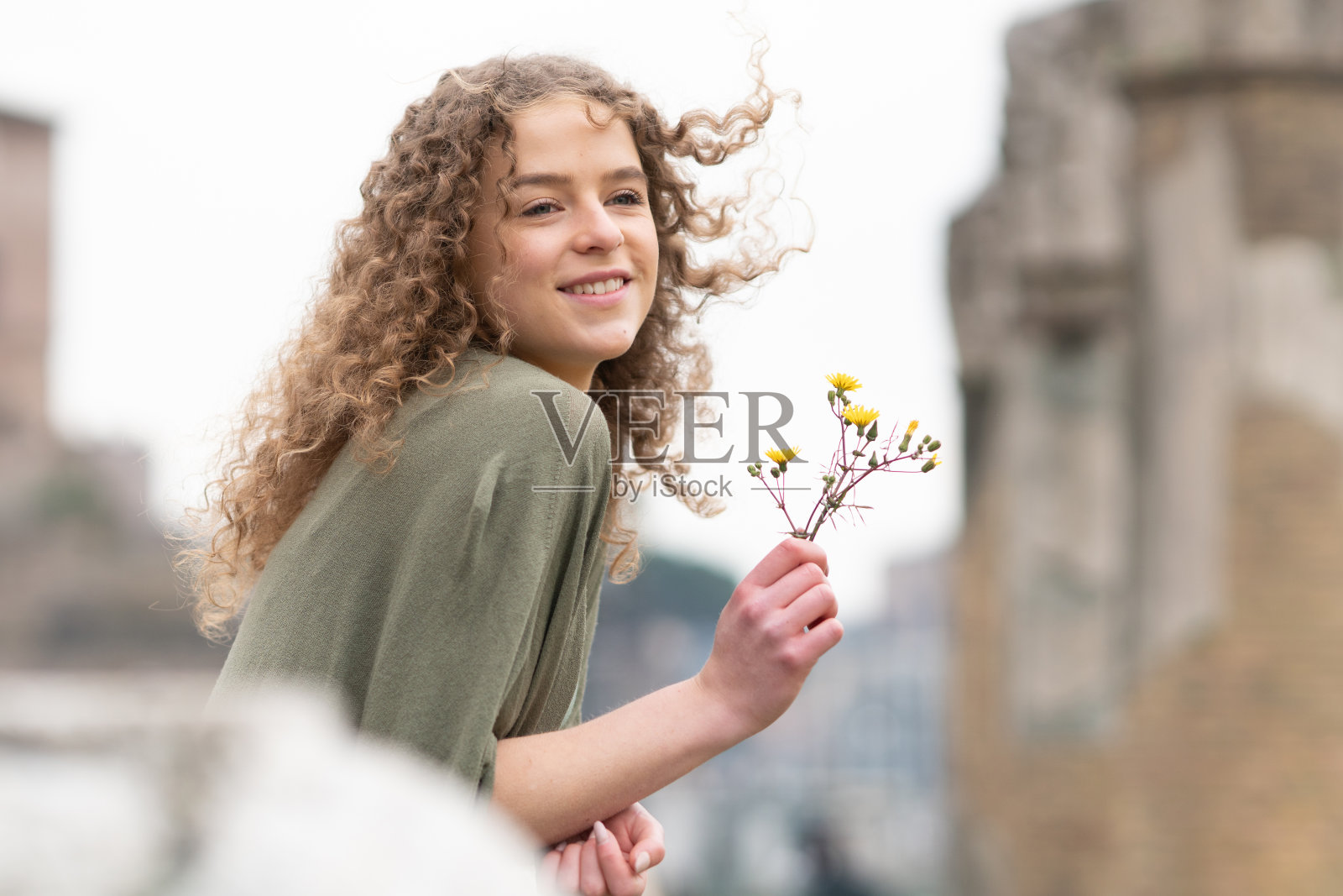 女人拿着花看罗马古代纪念碑照片摄影图片