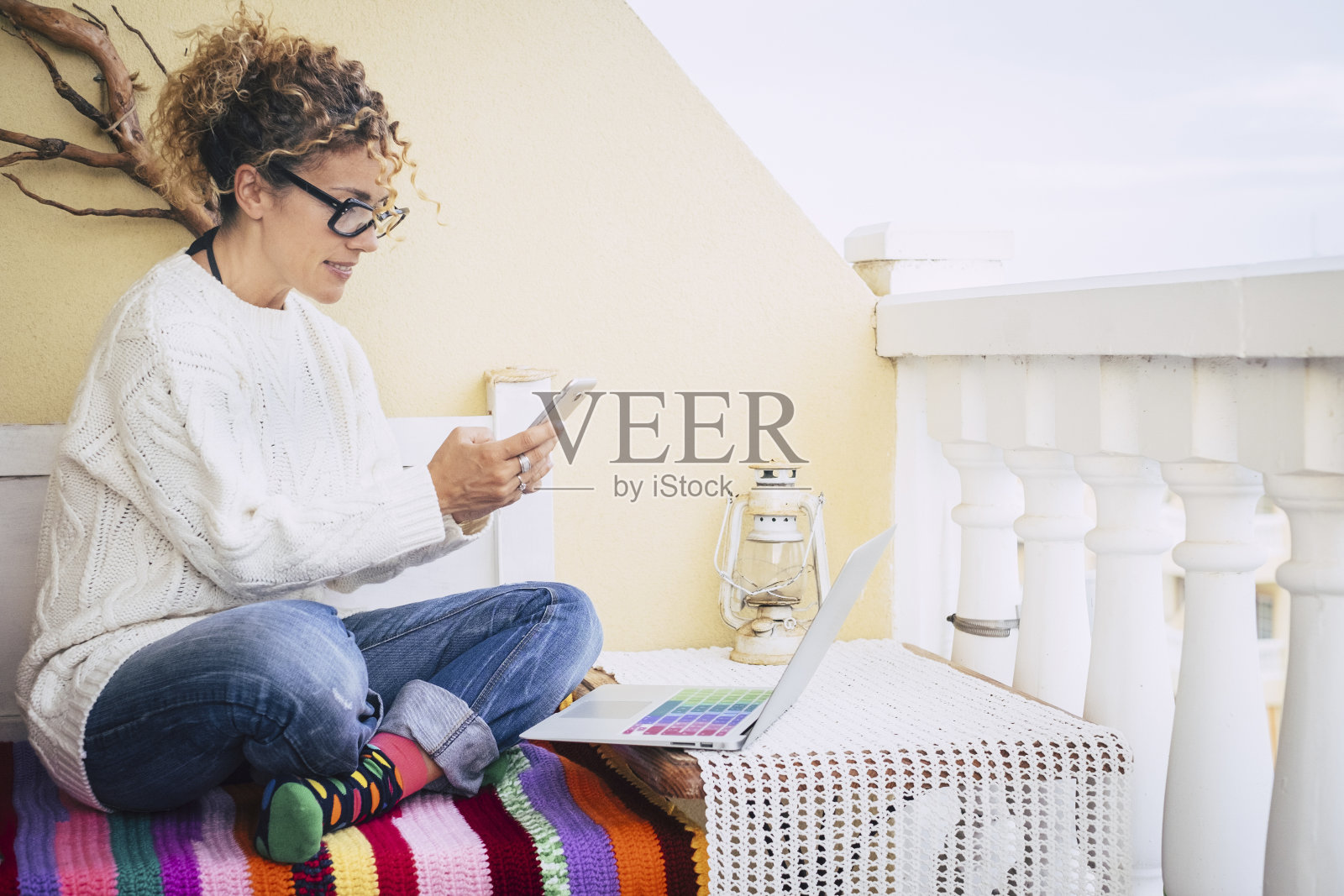 充满色彩的图像为中年妇女工作自由的笔记本电脑在室外的露台，在背景的旧古董灯替代一种办公室在独立工作。生活方式FPR美丽的女性照片摄影图片