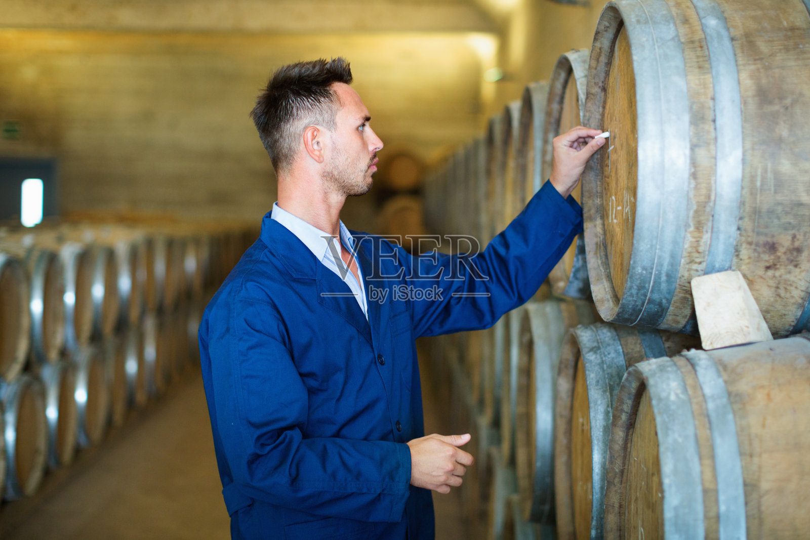 穿外套的年轻人在记录葡萄酒工厂照片摄影图片