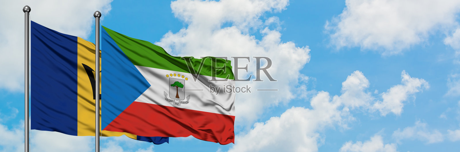 巴巴多斯和赤道几内亚的国旗在风中飘扬，对抗着白色多云的蓝天。外交理念，国际关系。照片摄影图片