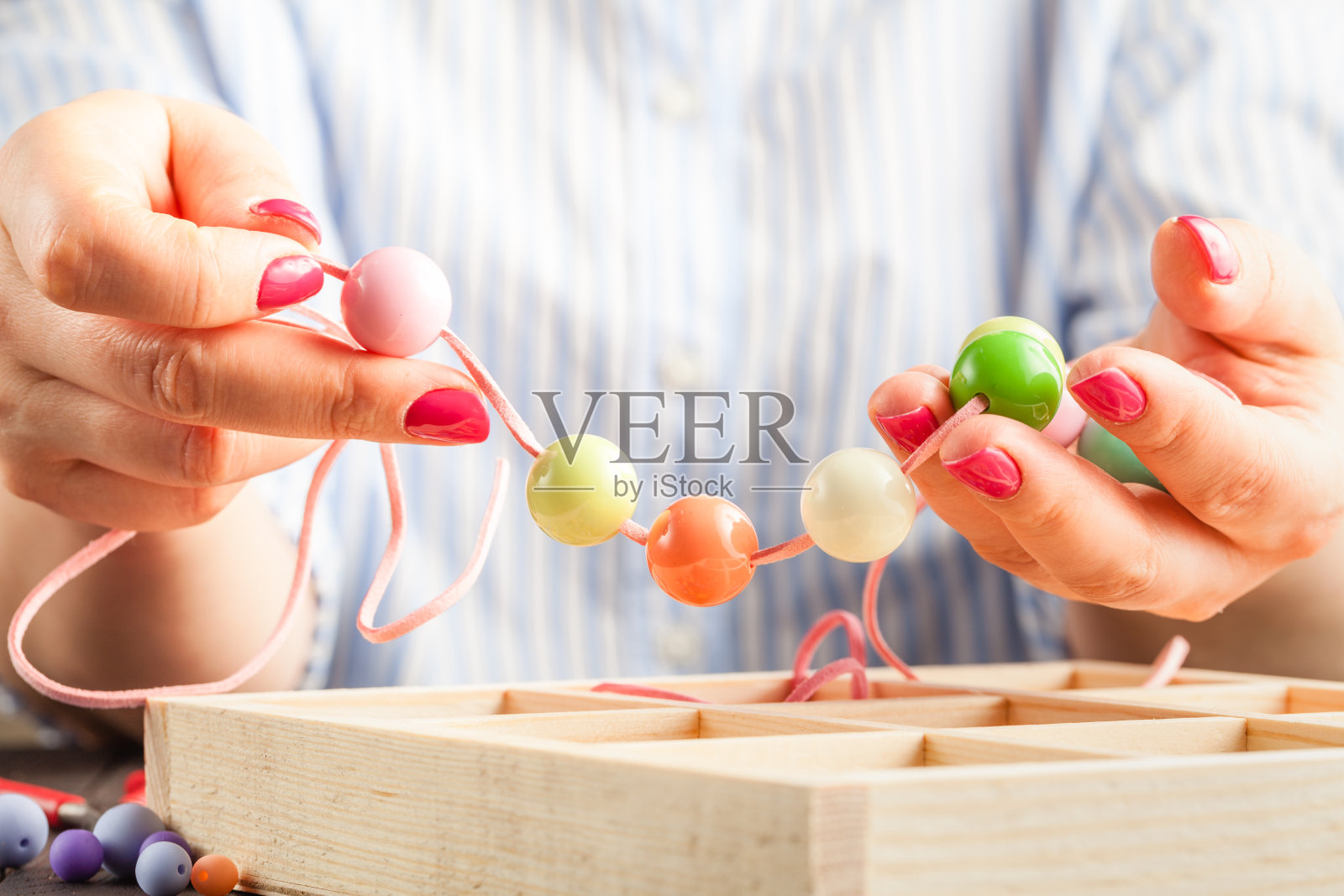 手工制作的珠宝。一个女人在尝试自制的手镯照片摄影图片