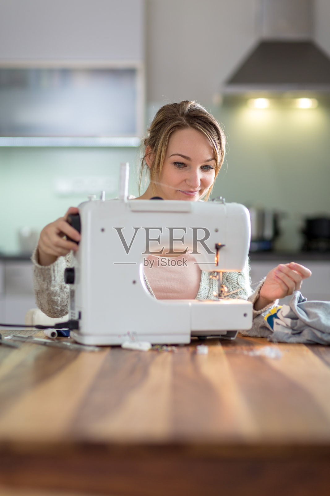 用缝纫机缝衣服的漂亮年轻女人照片摄影图片