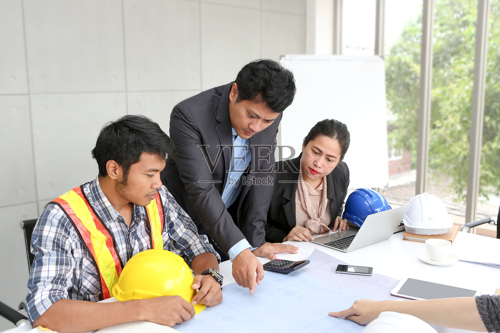 团队工程师在办公室会议室工作。团队工作人员正在讨论施工计划。电工、木匠或技术操作工、劳工或移动操作工。亚洲集团。照片摄影图片