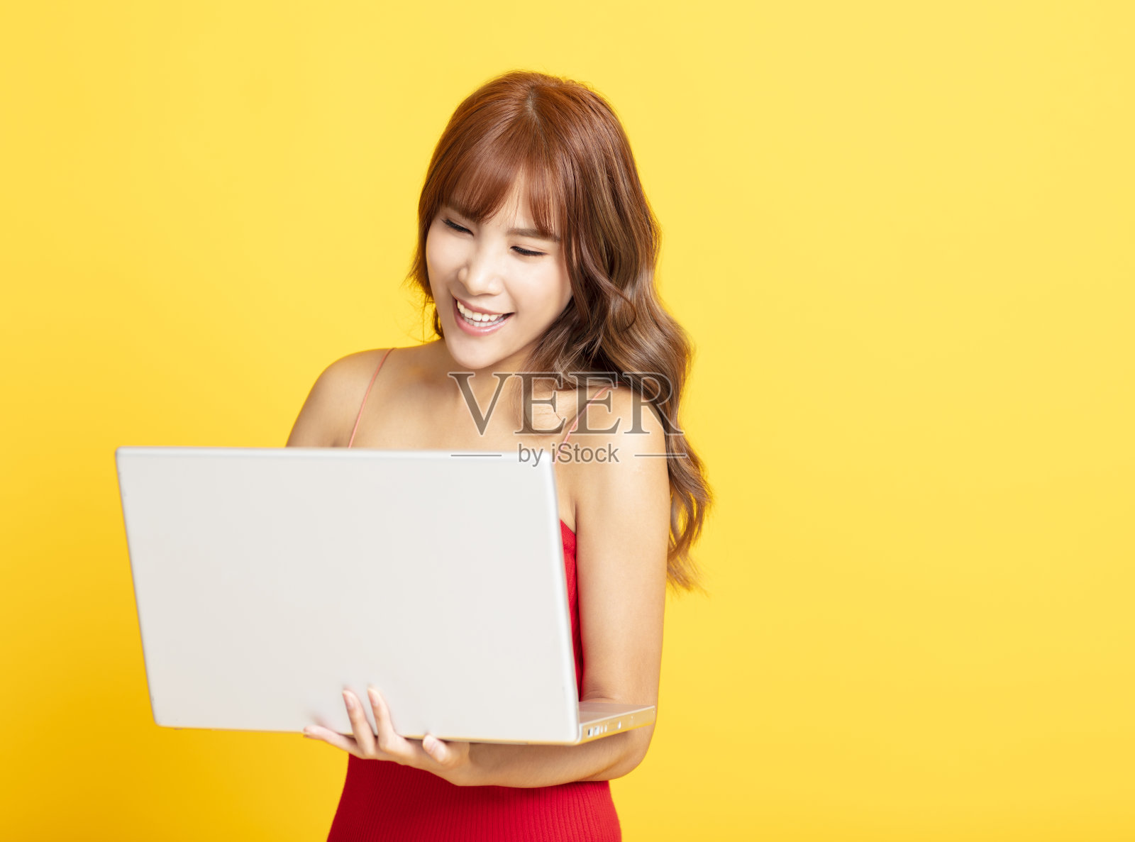 微笑的年轻女子拿着笔记本电脑照片摄影图片