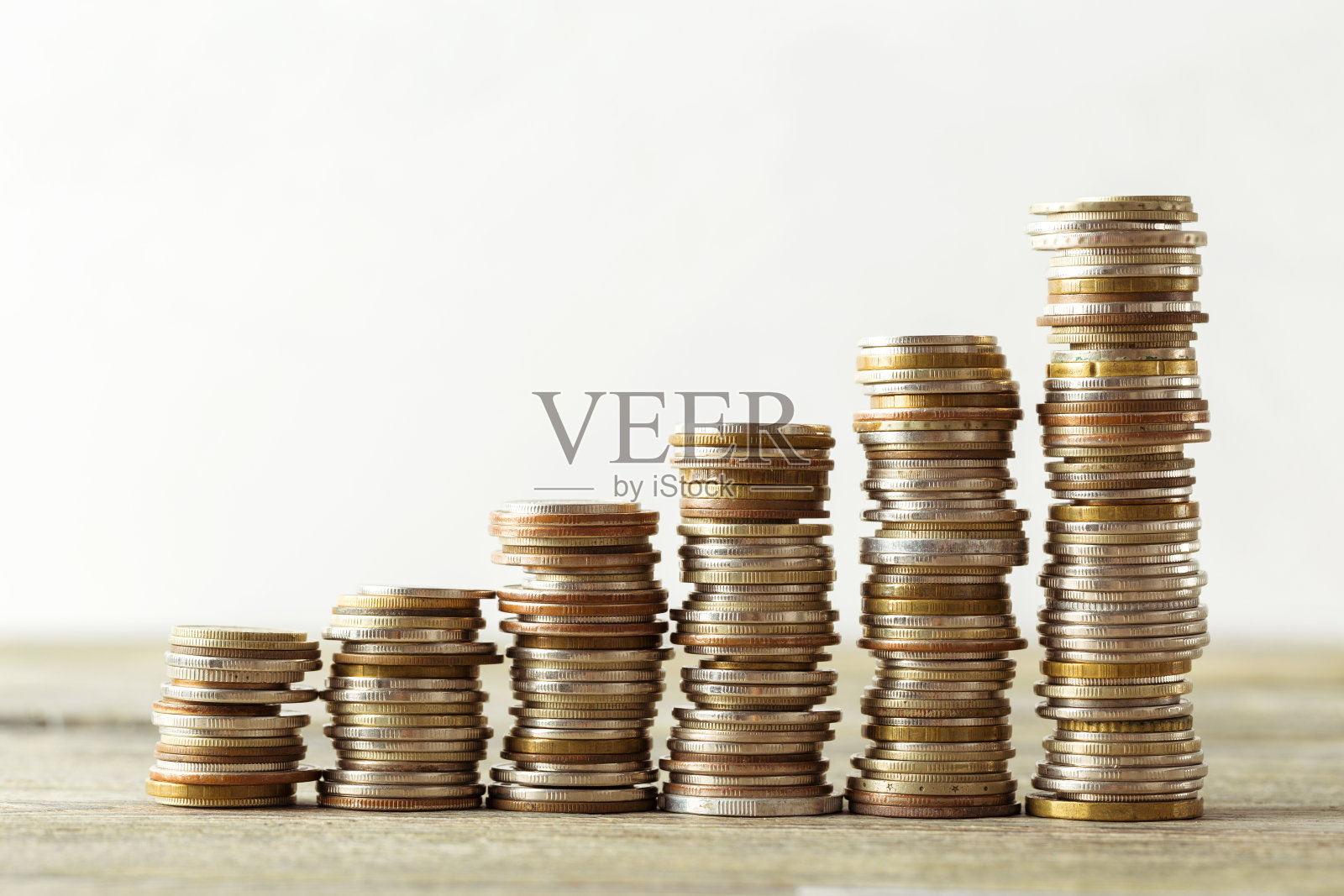 硬币堆放在木桌上照片摄影图片