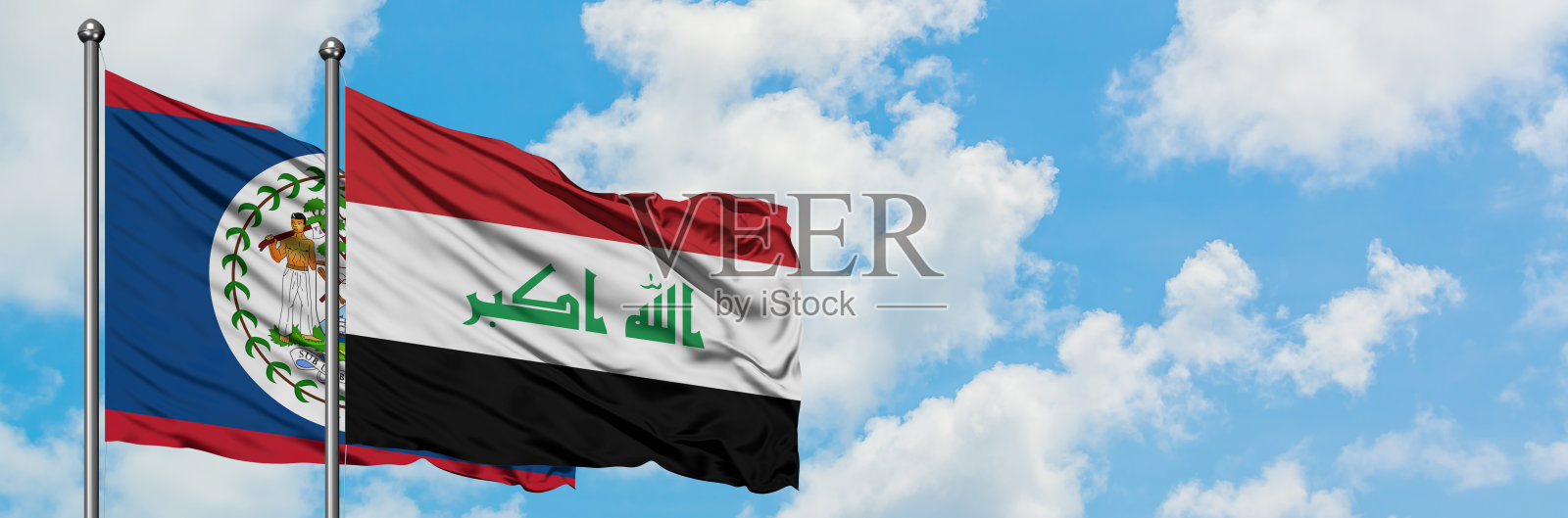 伯利兹和伊拉克国旗在蓝天下飘扬，外交概念和国际关系照片摄影图片