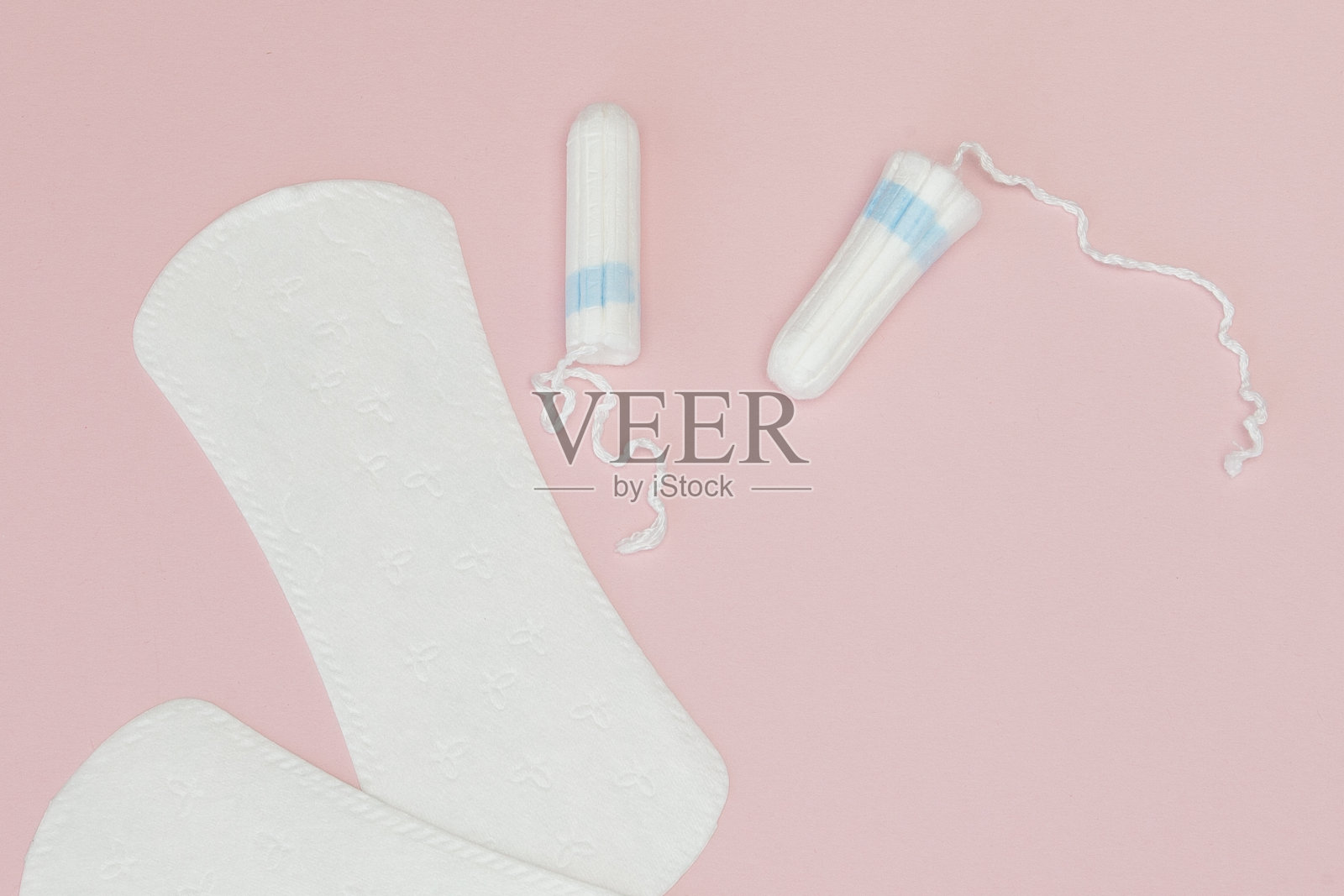 女性私密卫生用品——粉色背景的卫生巾和卫生棉条，拷贝空间。月经期的概念。俯视图，平放，复制空间照片摄影图片