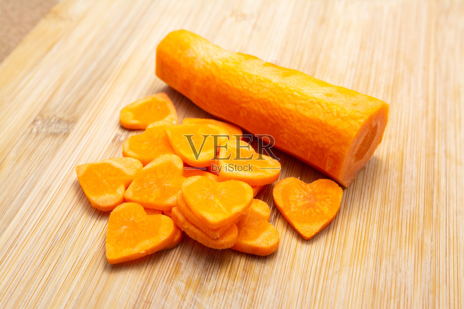 切成薄片的胡萝卜放在砧板上准备烹调。照片摄影图片