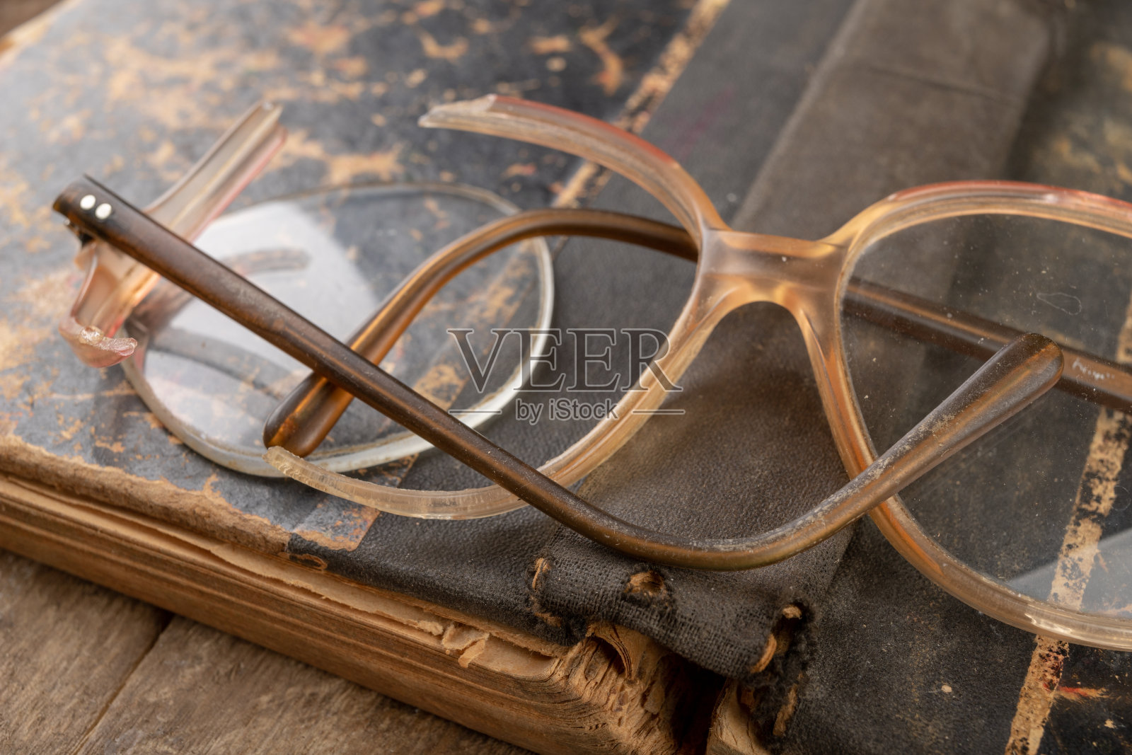 镜框破碎。旧书和眼镜。黑暗的背景。照片摄影图片