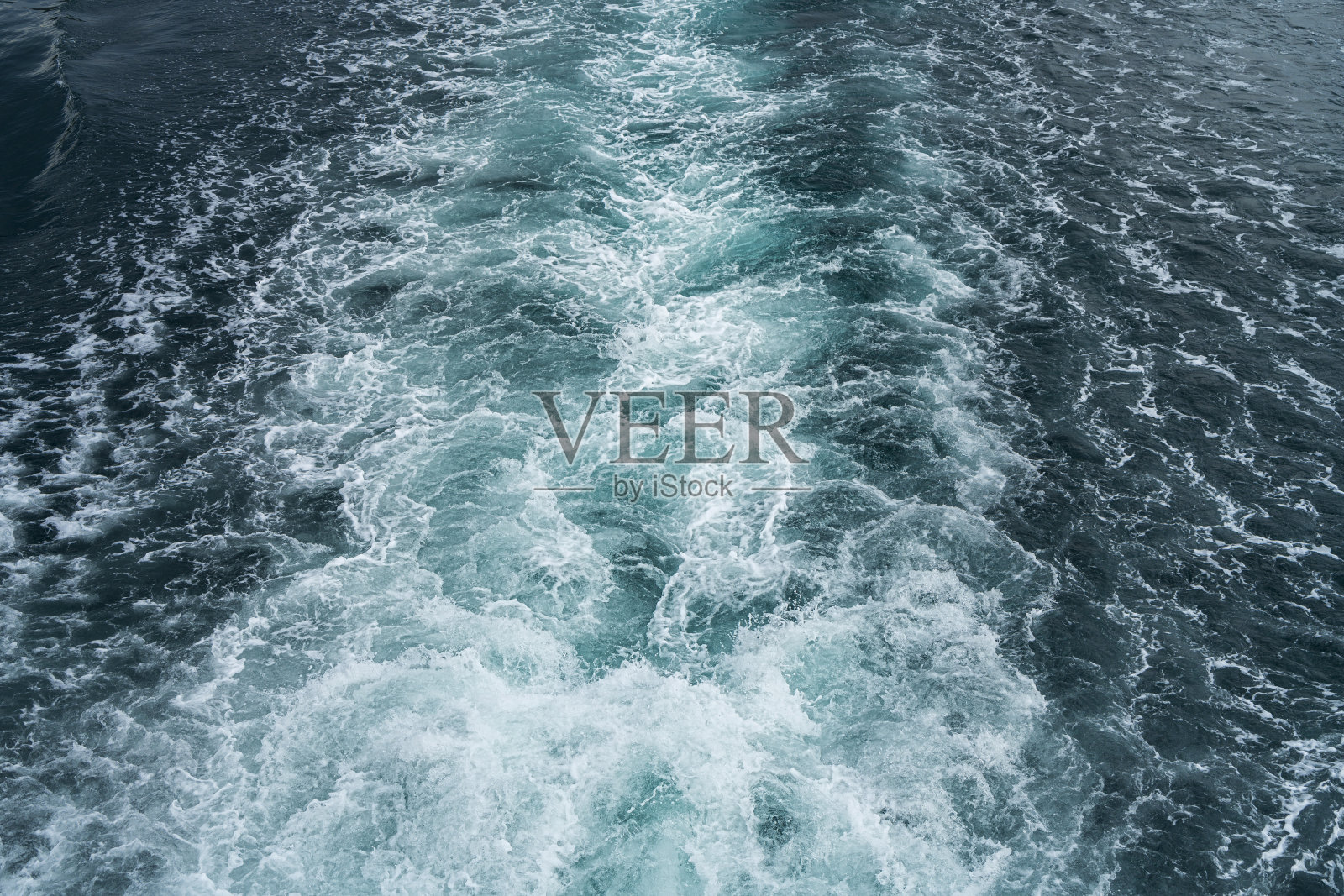 在海面上的渡船后面的水迹照片摄影图片