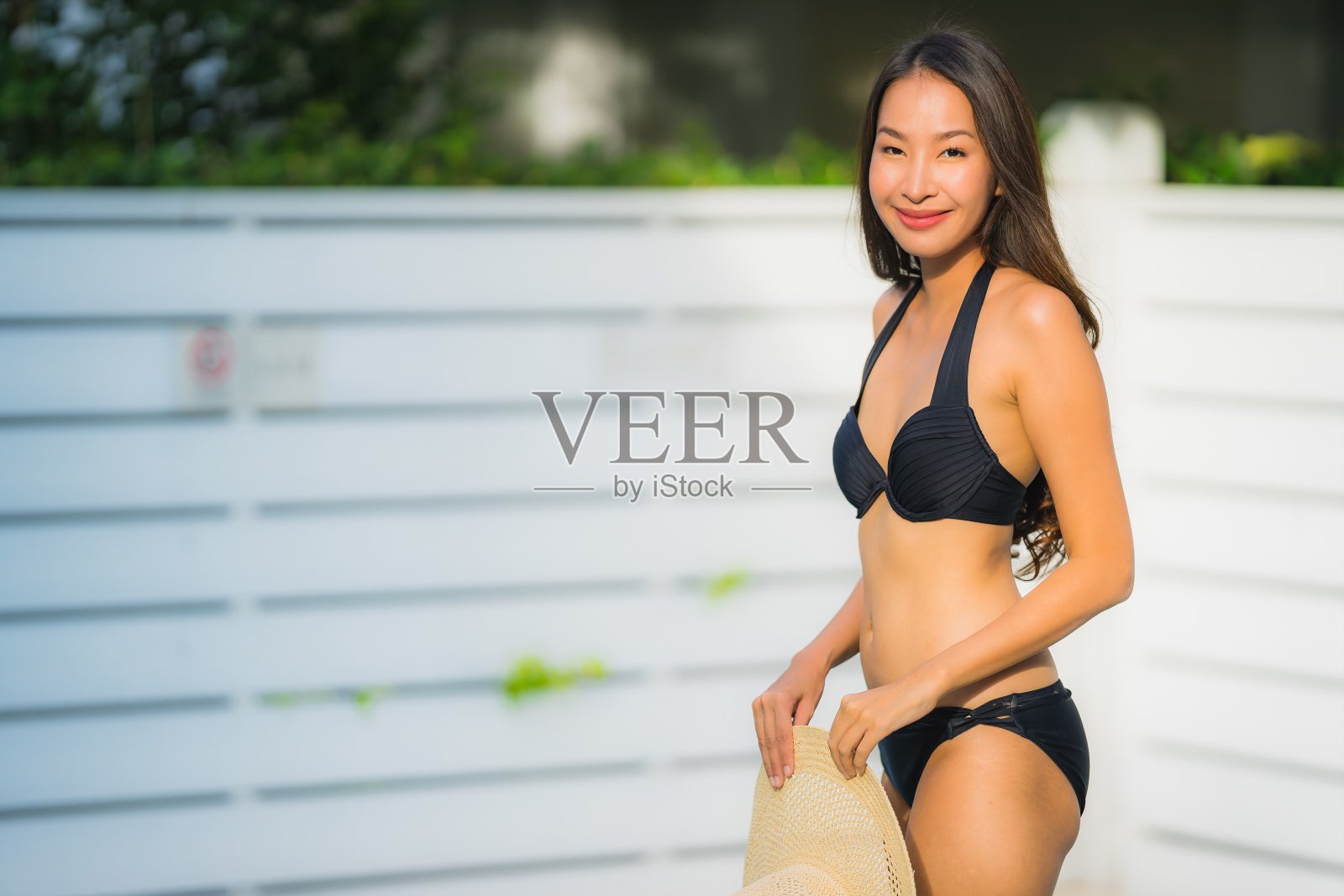 肖像美丽的年轻亚洲女子微笑快乐放松周围的游泳池，在酒店度假休闲照片摄影图片