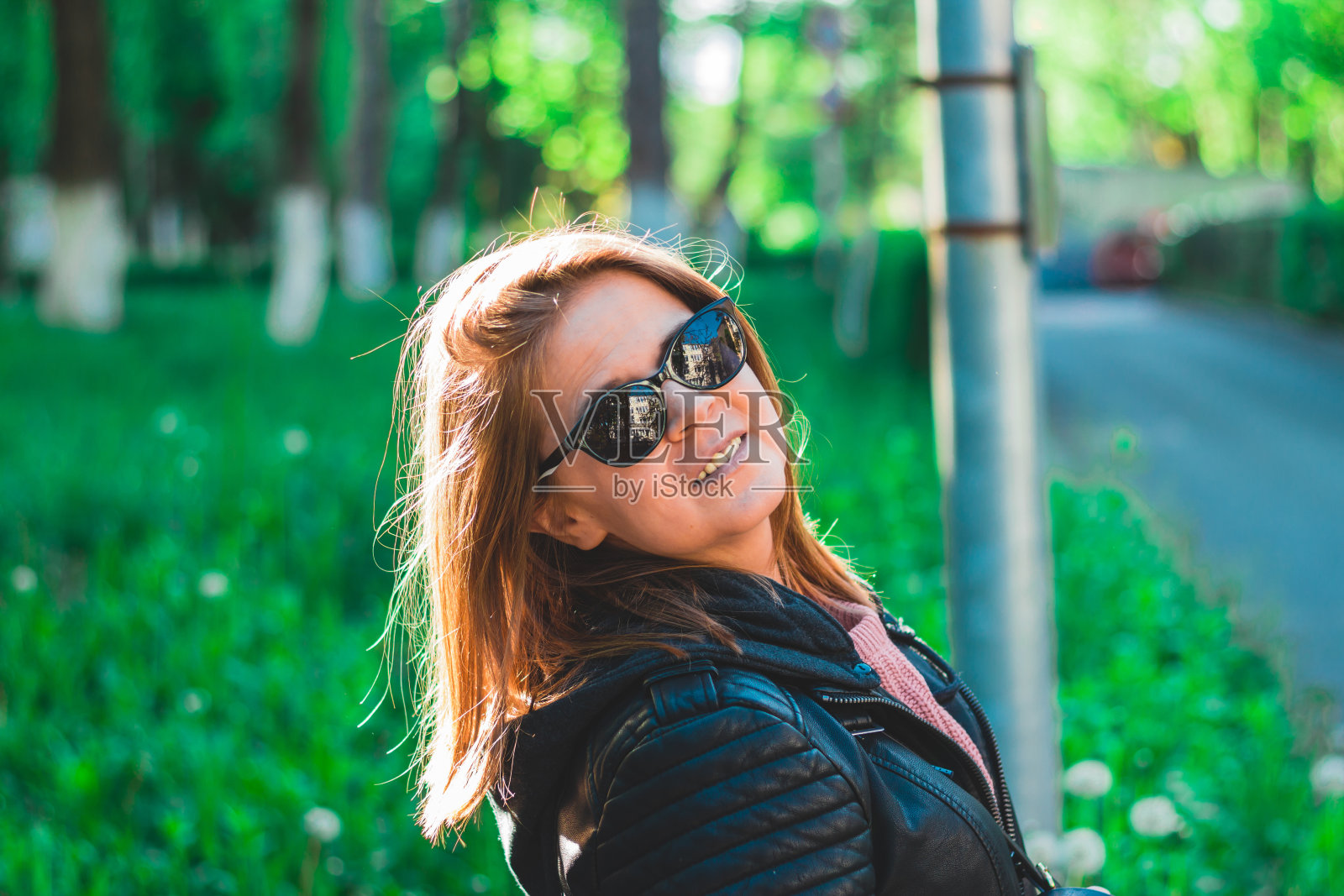 戴着太阳镜在户外微笑的快乐女人照片摄影图片