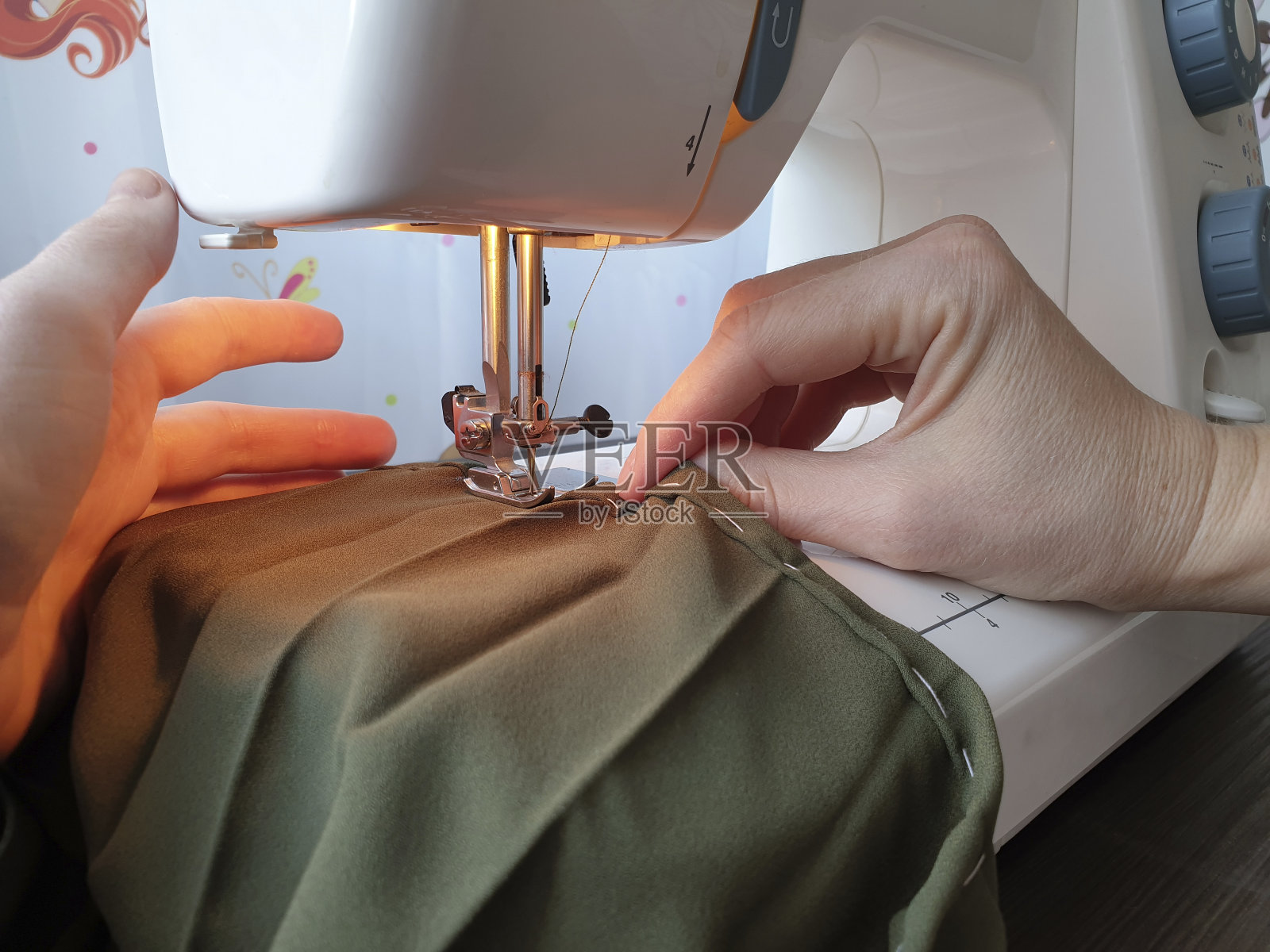 妇女在缝纫机上缝衣服。特写镜头。照片摄影图片