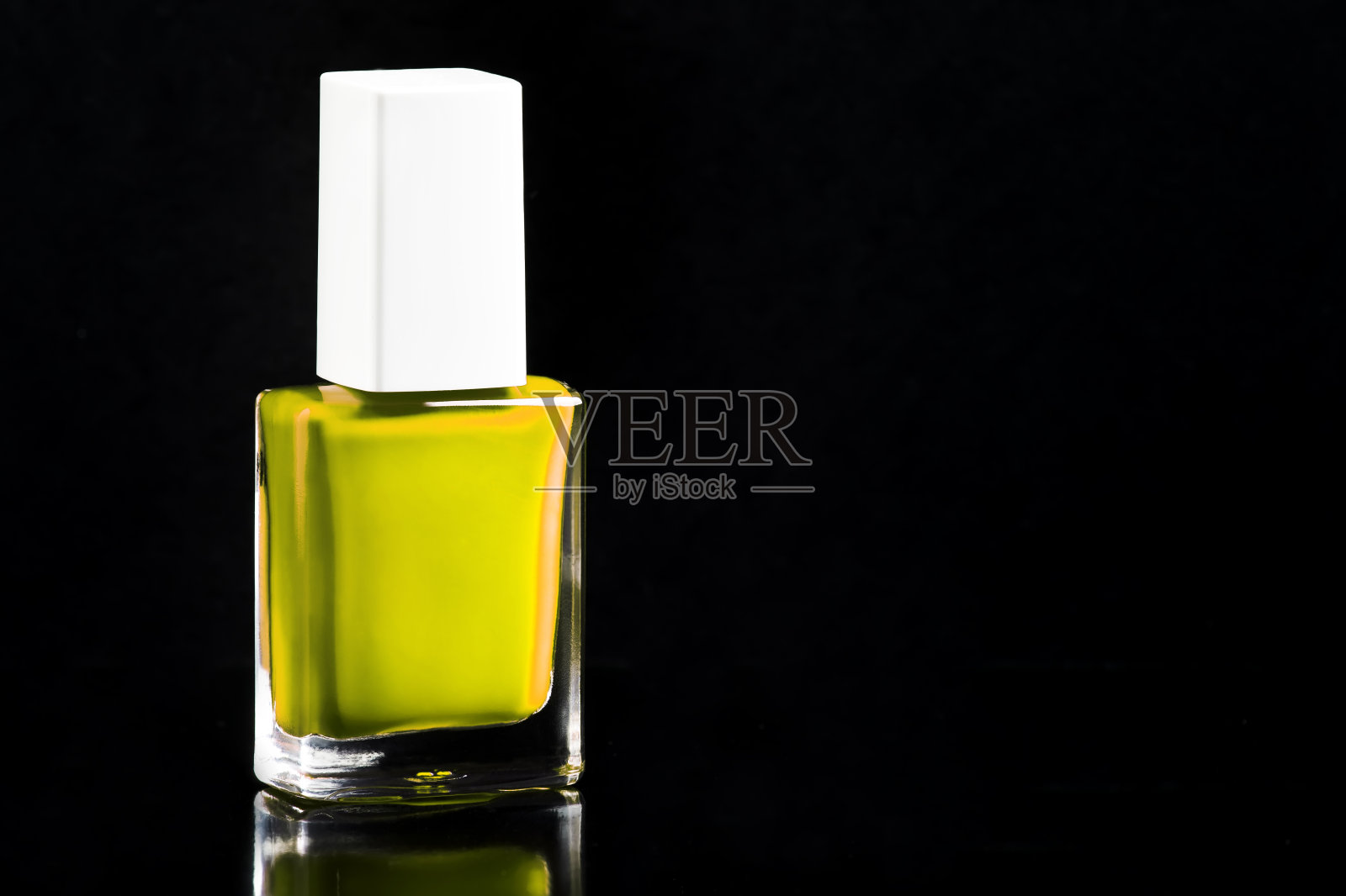 石灰绿色霓虹指甲油在瓶子隔离光泽黑色背景，复制空间，选择性焦点照片摄影图片