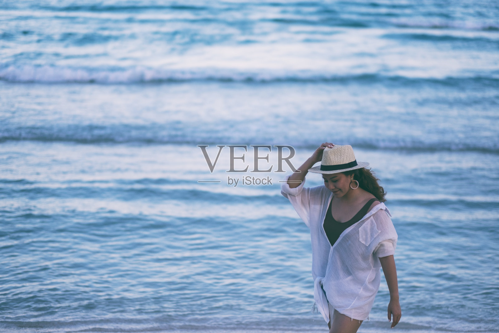 一个女人站在海滩上照片摄影图片