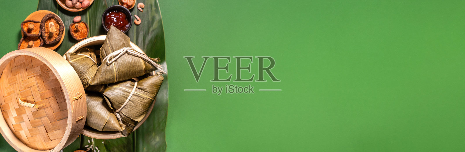 粽子、蒸熟的粽子以绿色的餐桌为背景，食物中有端午的概念，拉近，复制空间，俯视图，平铺照片摄影图片