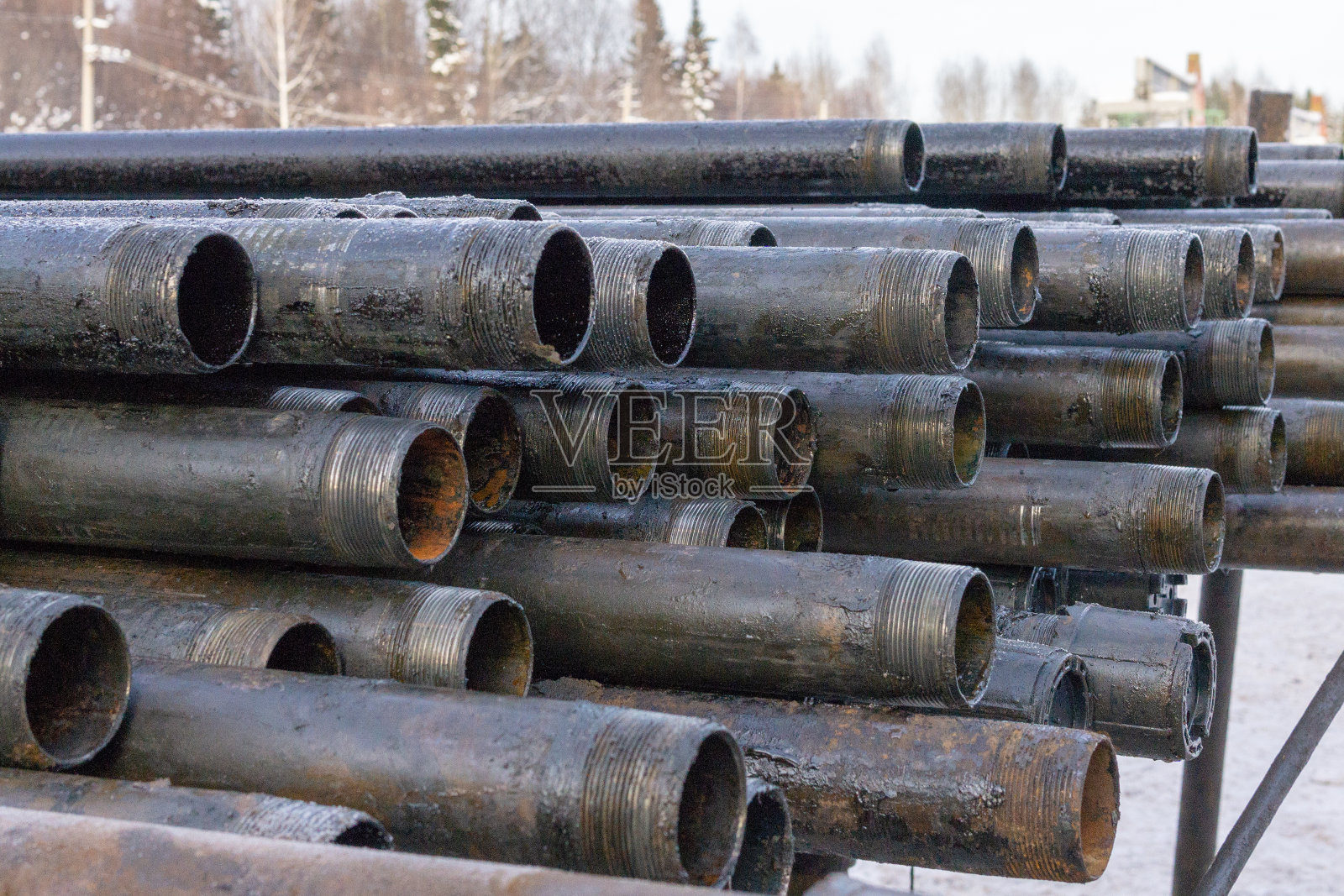 海上油气生产管道。井下钻井平台。把管子放在甲板上。在油气仓库庭院中铺设的钻杆外壳的视图。照片摄影图片