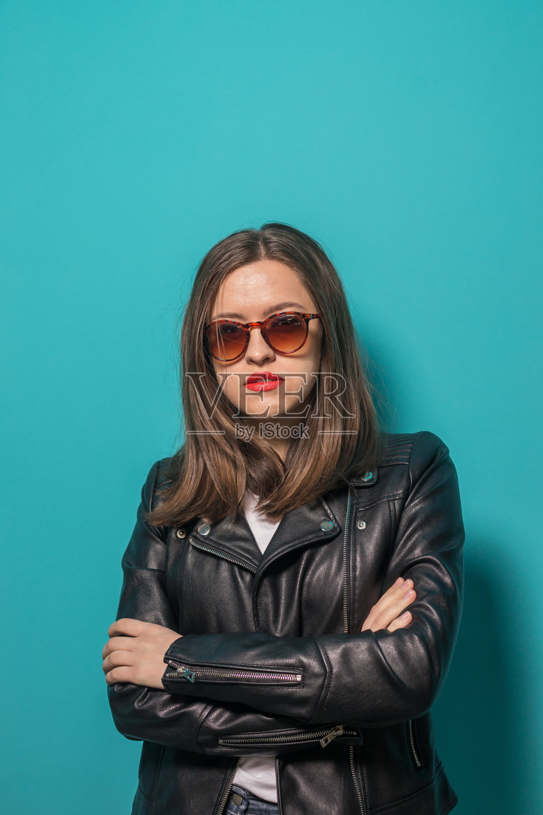 时尚的女孩在皮夹克，在粉红色和蓝色霓虹灯背景下的墨镜。照片摄影图片