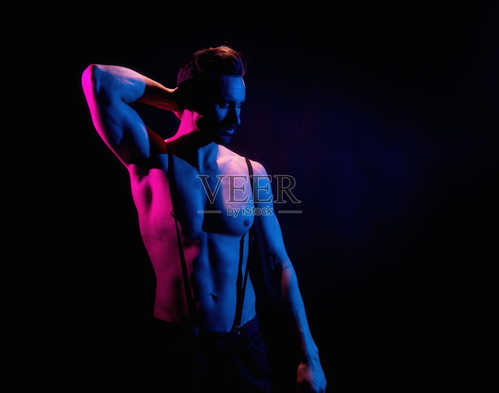 英俊的男子在黑色背景与红色和蓝色照明照片摄影图片