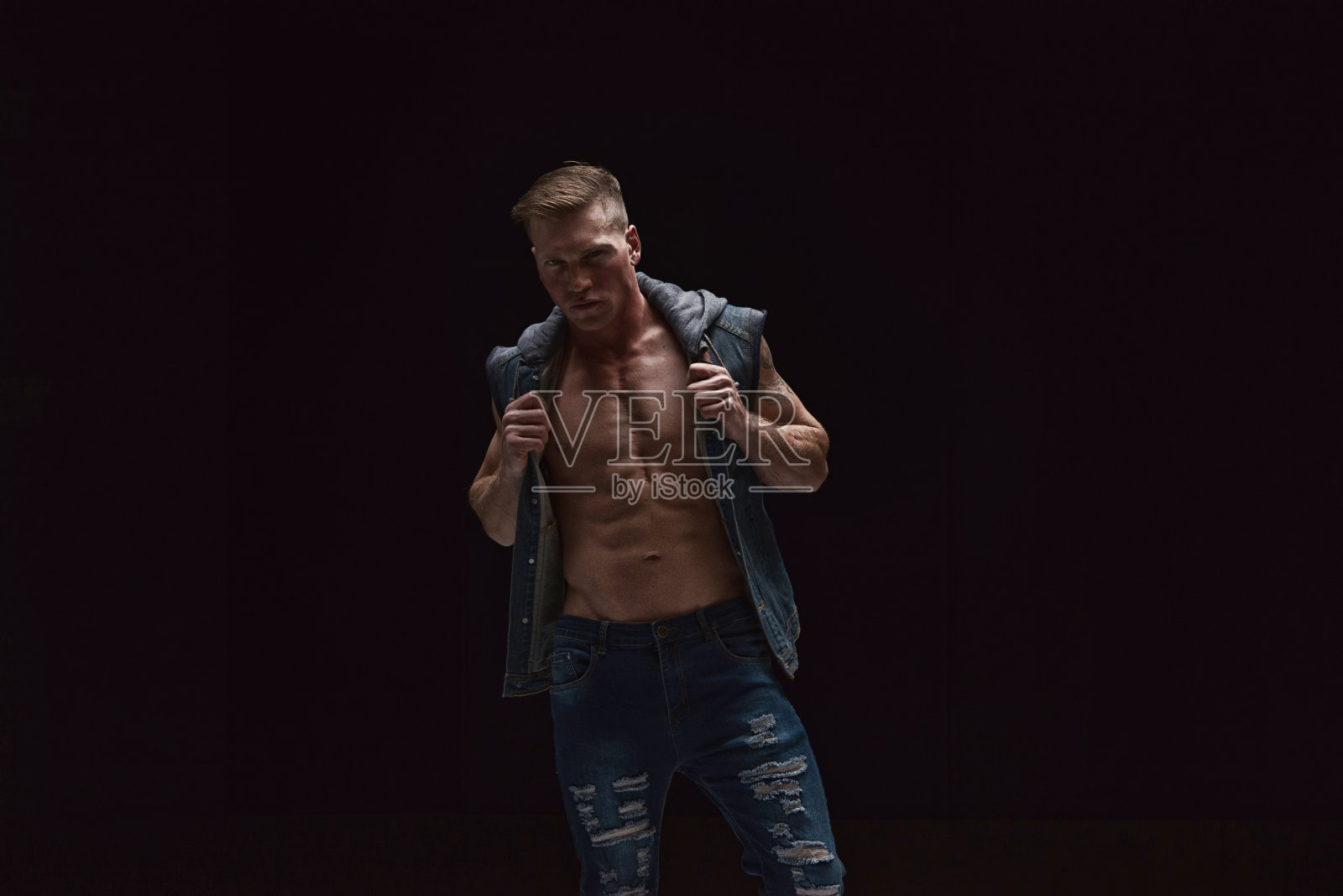 穿着背心和牛仔裤的帅哥照片摄影图片