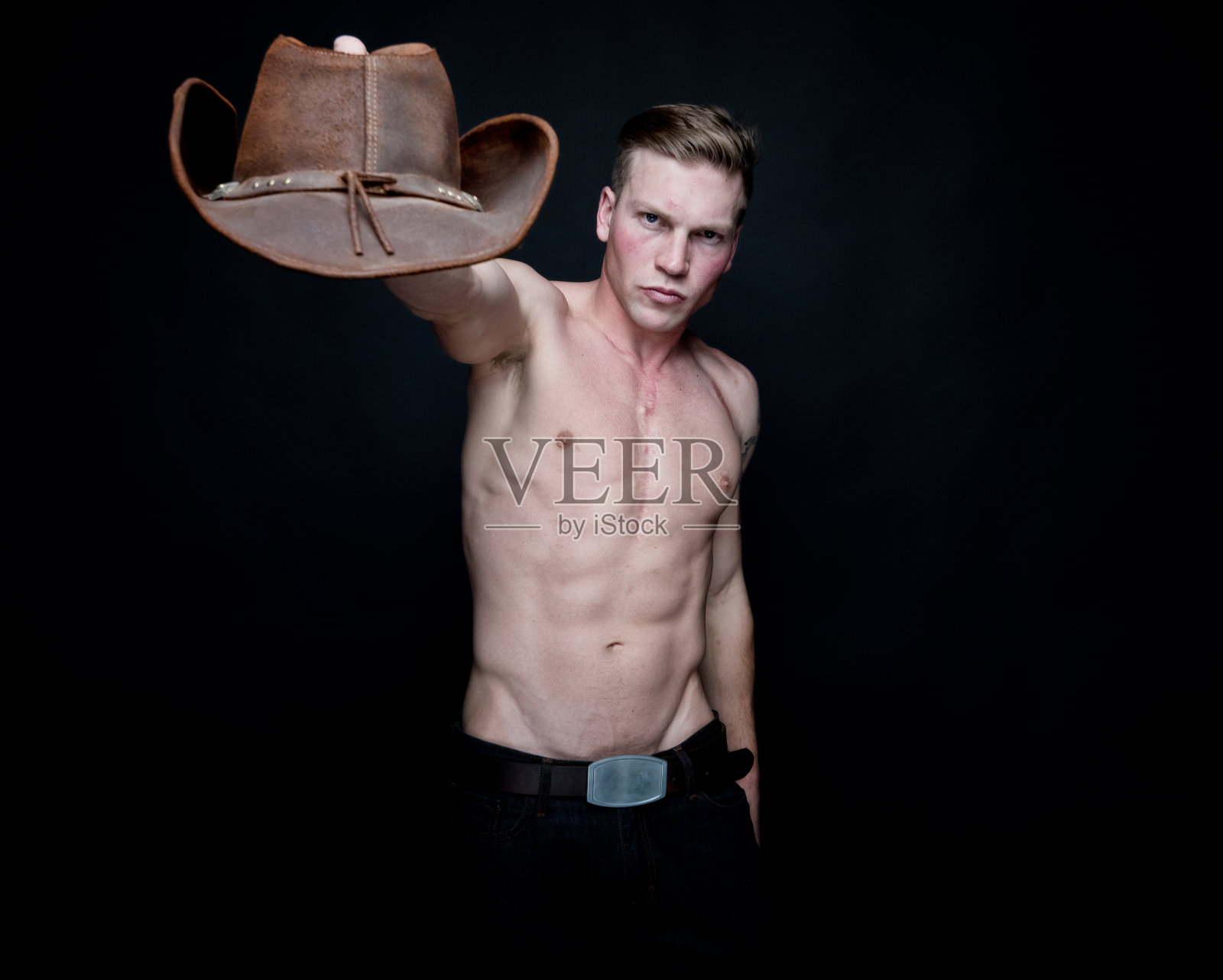 迷人的赤膊牛仔在黑色的背景照片摄影图片