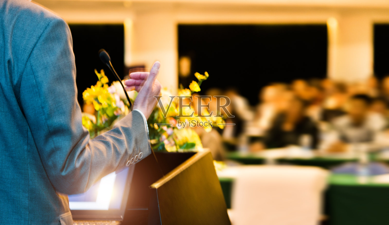 一个面目全非的商人在会议厅的观众面前发表演讲照片摄影图片