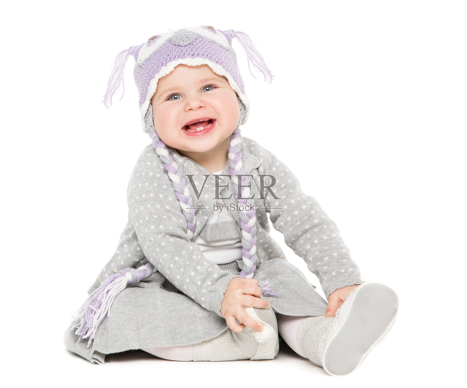 婴儿坐在白色，快乐的孩子在羊毛帽子，美丽的女孩肖像照片摄影图片