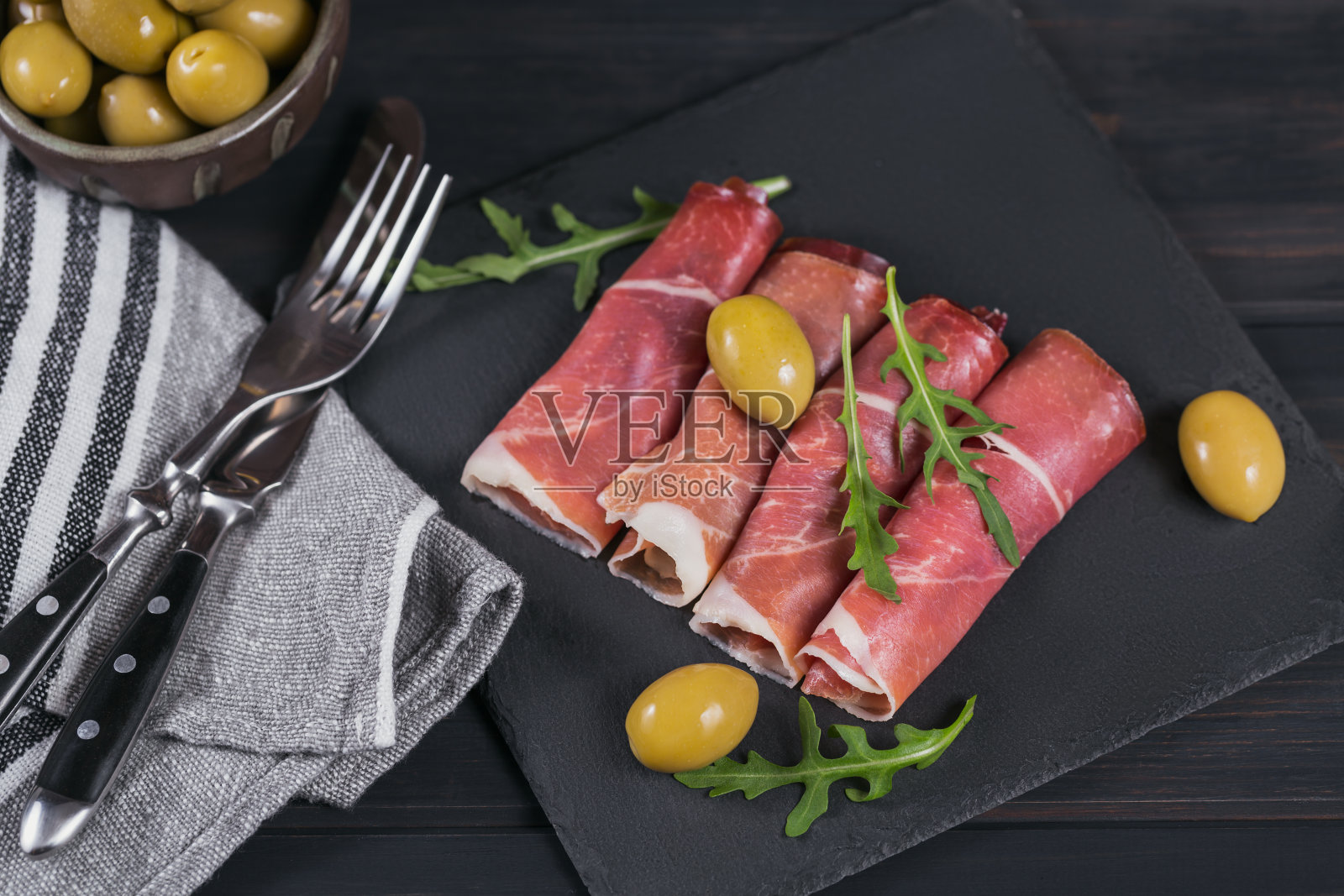 黑石制大浅盘，配上腌火腿片或西班牙塞拉诺火腿或意大利火腿照片摄影图片