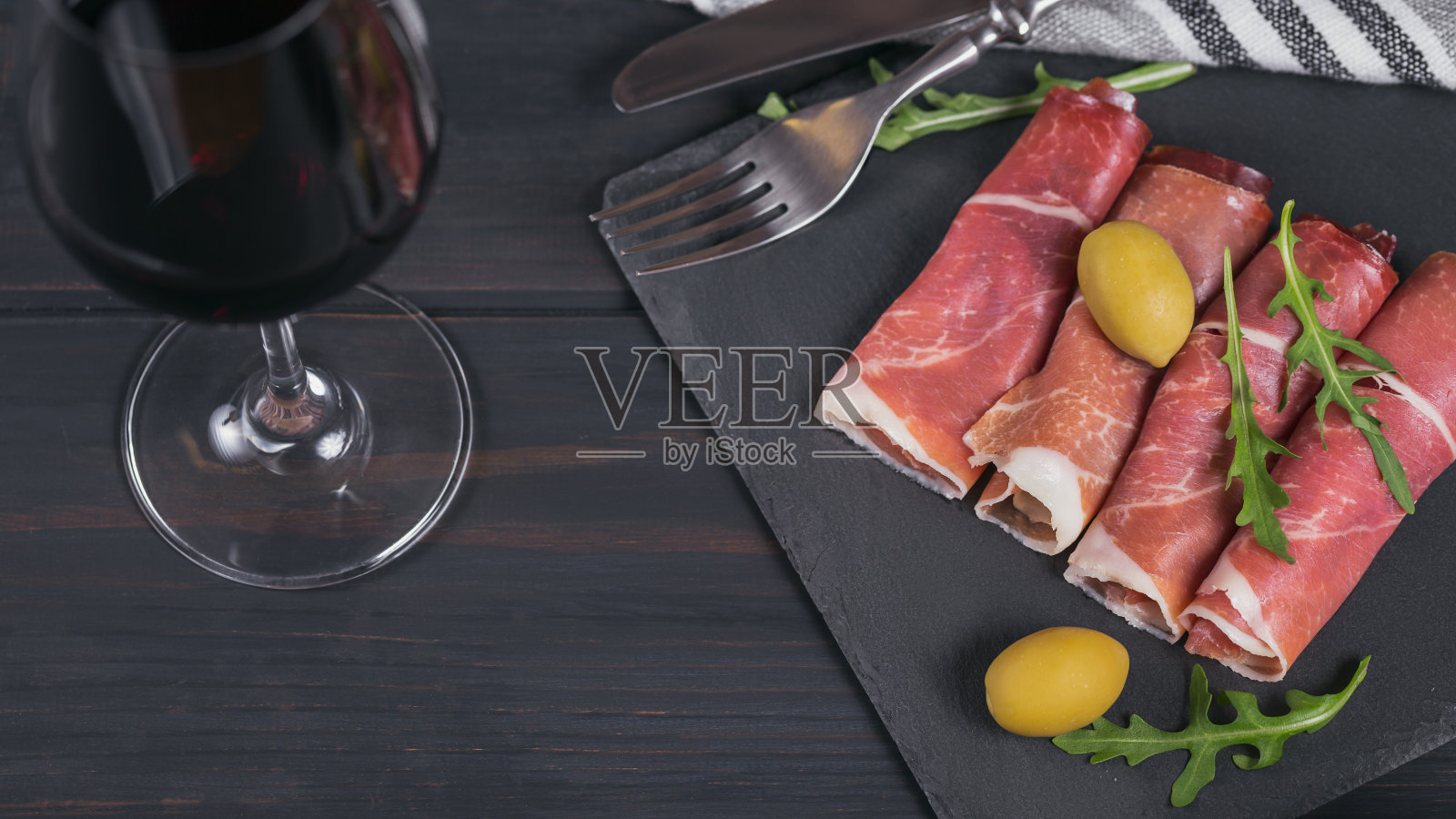 黑石制大浅盘，配上腌火腿片或西班牙塞拉诺火腿或意大利火腿照片摄影图片
