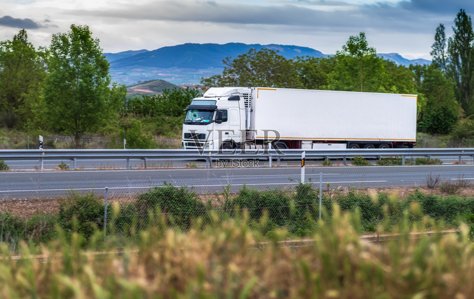 一辆白色卡车在阴天行驶在路上照片摄影图片