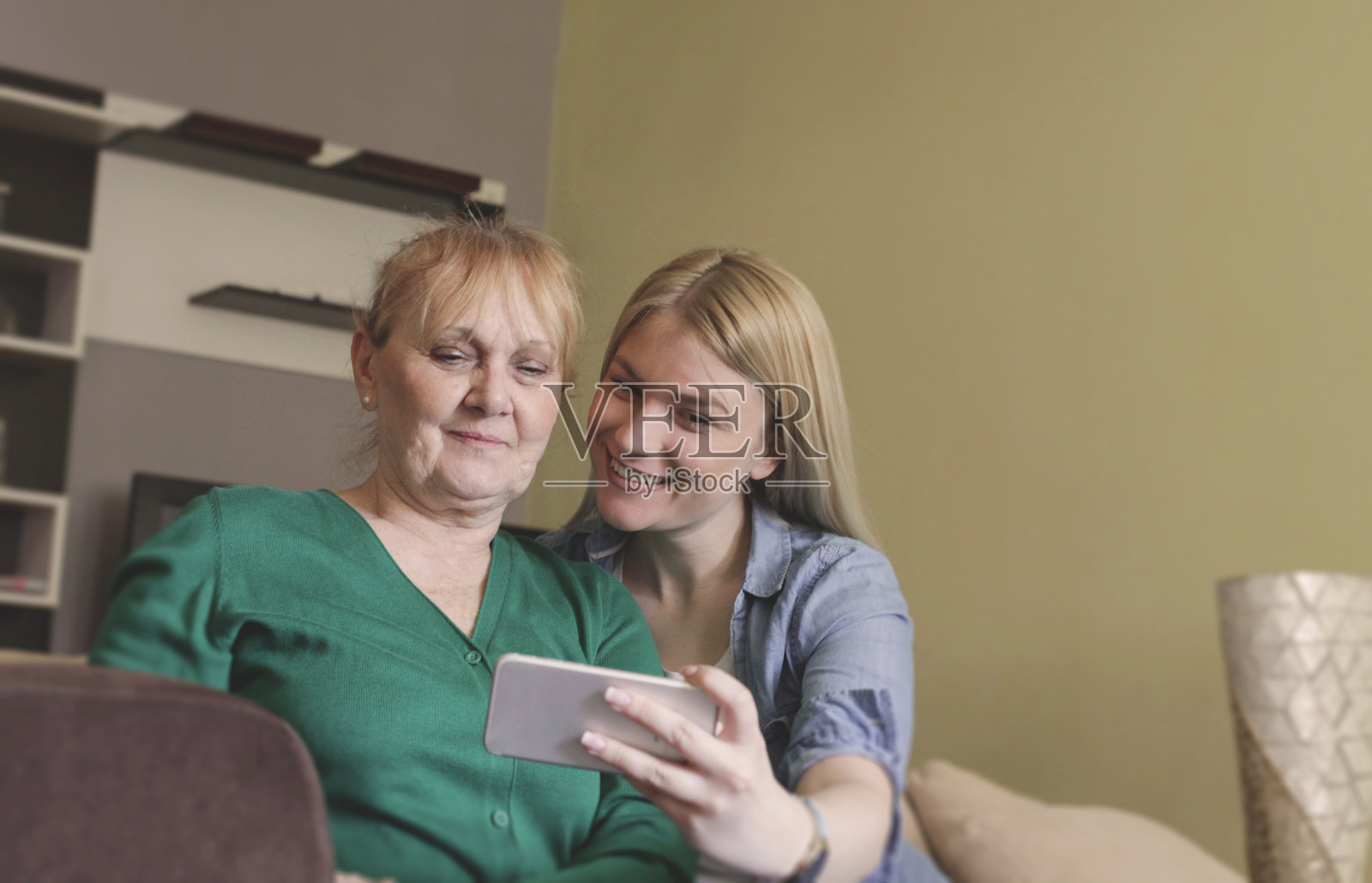 一位年长的女士和她的女儿在玩自拍。照片摄影图片