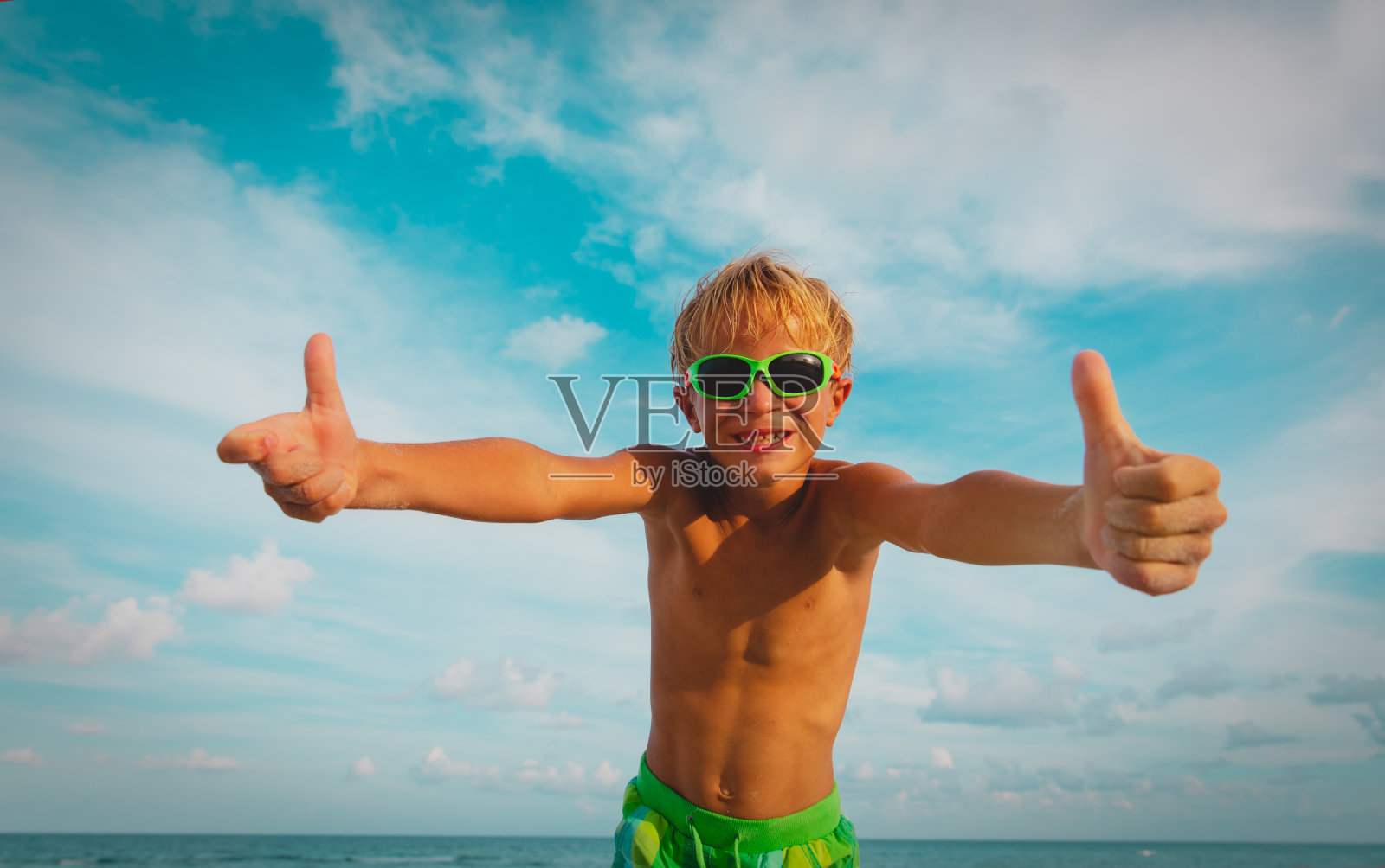 快乐的男孩大拇指向上享受热带海滩照片摄影图片