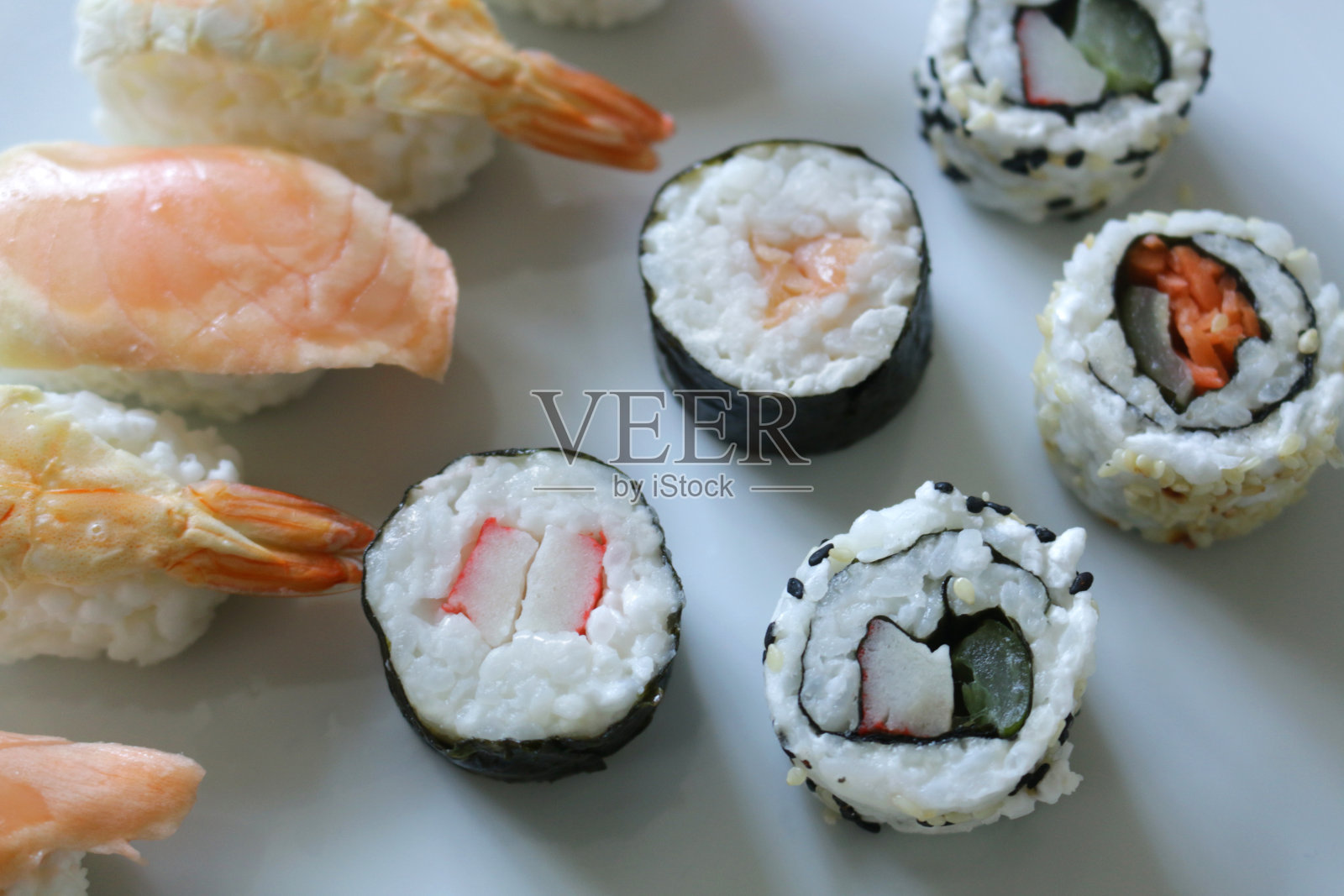 冷冻寿司盘装在塑料托盘里，新鲜准备的海鲜，日本寿司的种类-寿司，细卷寿司/真卷寿司，futomaki，浦卷寿司，手握寿司，粗卷寿司，生鱼片，新鲜鲑鱼，金枪鱼，虾，对虾，糯米饭，海藻皮照片摄影图片