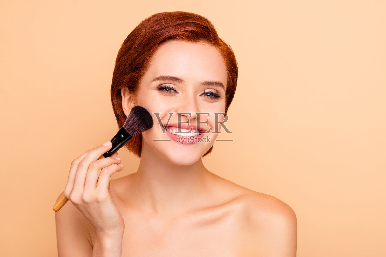 近距离拍摄的漂亮可爱甜美的娇艳迷人迷人迷人的女孩光滑干净清晰完美闪亮的完美无瑕的皮肤应用霜孤立的米色背景照片摄影图片