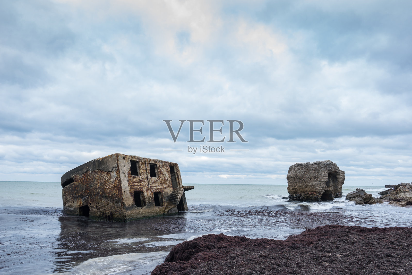 利耶帕亚海滩地堡。砖房，软水，海浪和岩石。暴风雨中的废弃军事废墟设施。在波罗的海建造兵营。利耶帕亚、拉脱维亚、欧洲。照片摄影图片