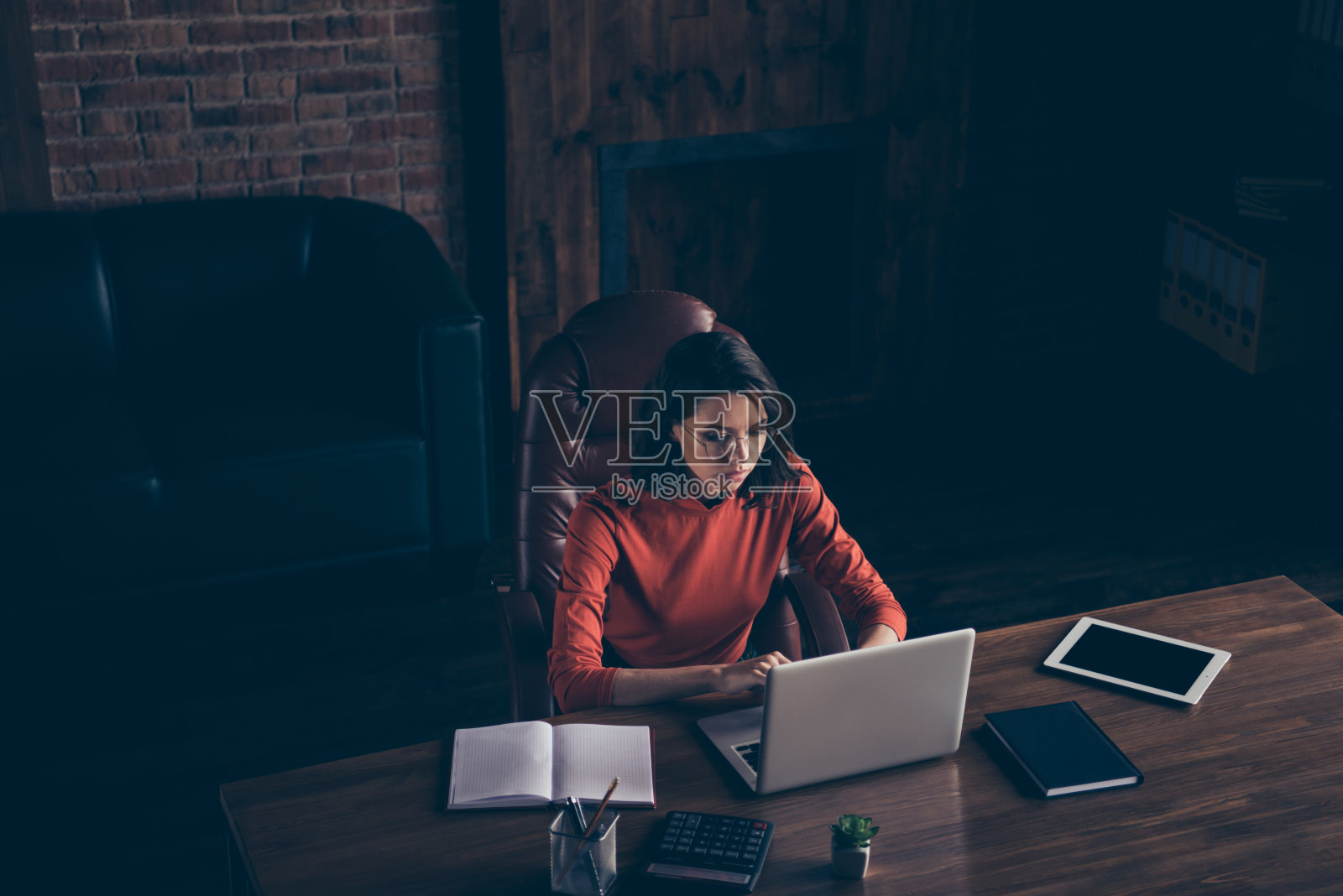 顶部以上高角度视角，深思熟虑专注的千禧代理律师规格红色套衫风格，时尚潮流决定选择解决方案搜索电脑坐扶手椅平板笔记本电脑计算器内部照片摄影图片