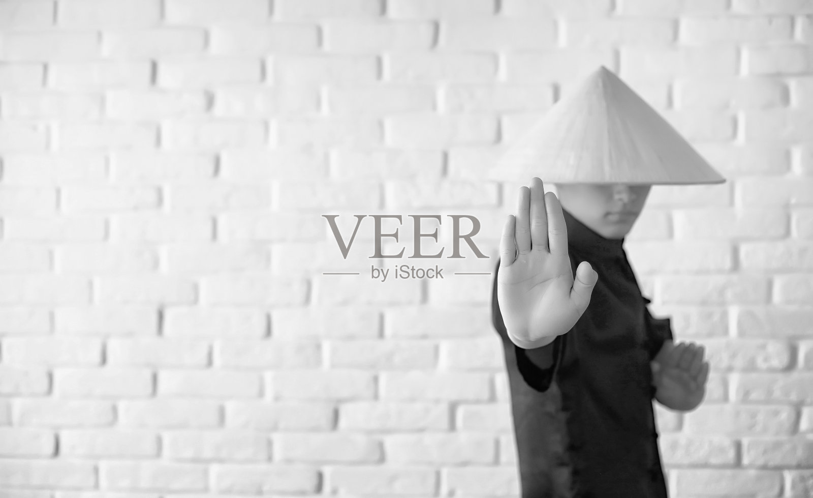 亚洲新手在白砖墙上照片摄影图片