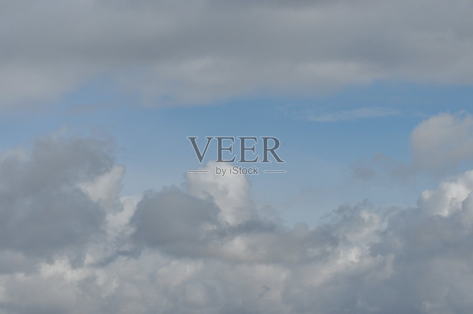 蓝蓝的天空映衬着蓬松的云朵。美丽的,晴朗的天气。照片摄影图片