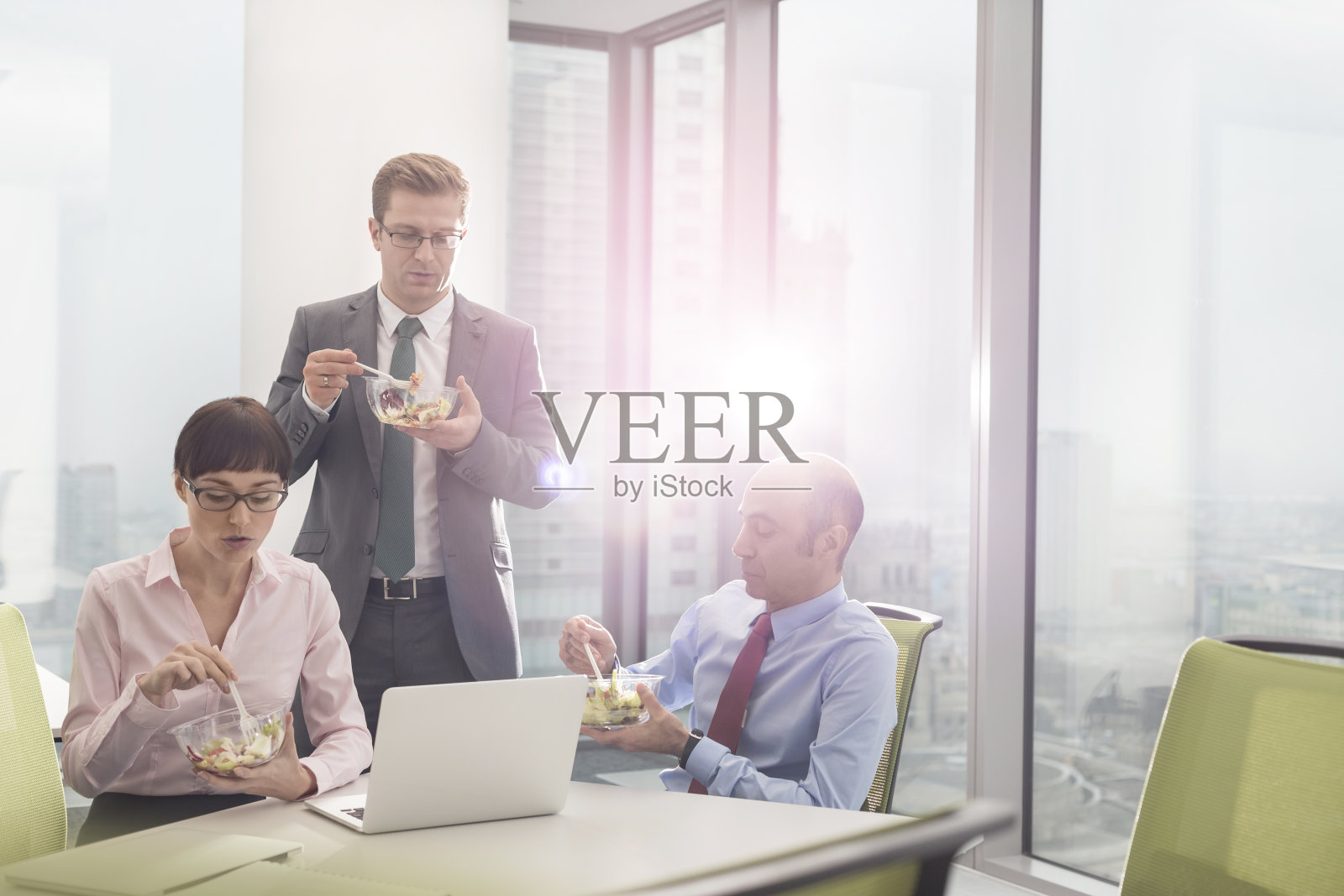 商务同事在办公室开会时在会议室吃午餐照片摄影图片