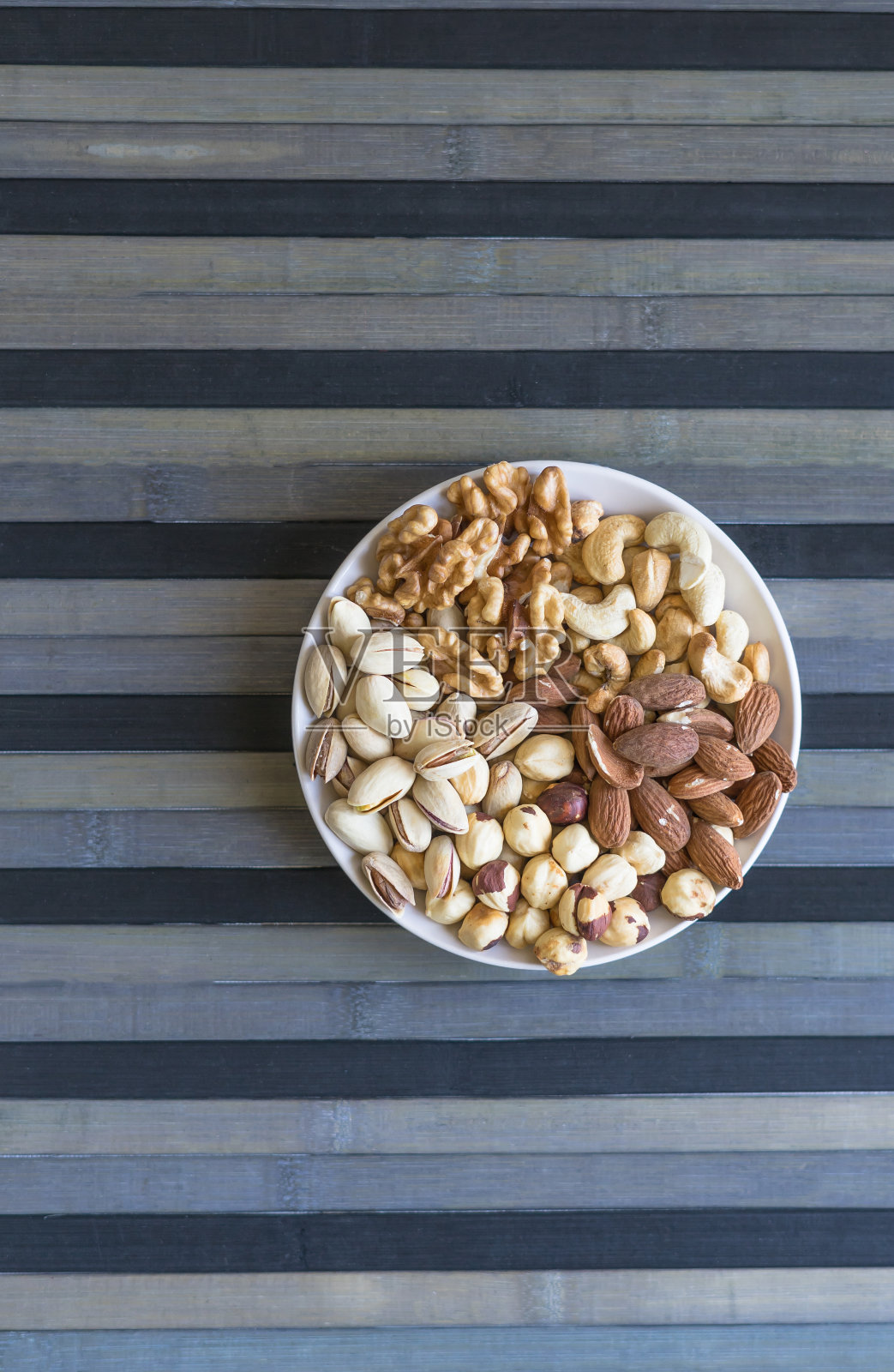 健康食品。坚果混合品种石纹理俯视图。收集不同的豆类为背景图像近距离的坚果，开心果，杏仁，腰果，花生，核桃。图像照片摄影图片