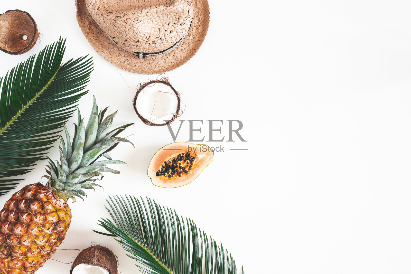 夏天组成。热带棕榈叶，帽子，椰子，菠萝，木瓜在白色的背景。夏天的概念。平铺，俯视图，拷贝空间照片摄影图片