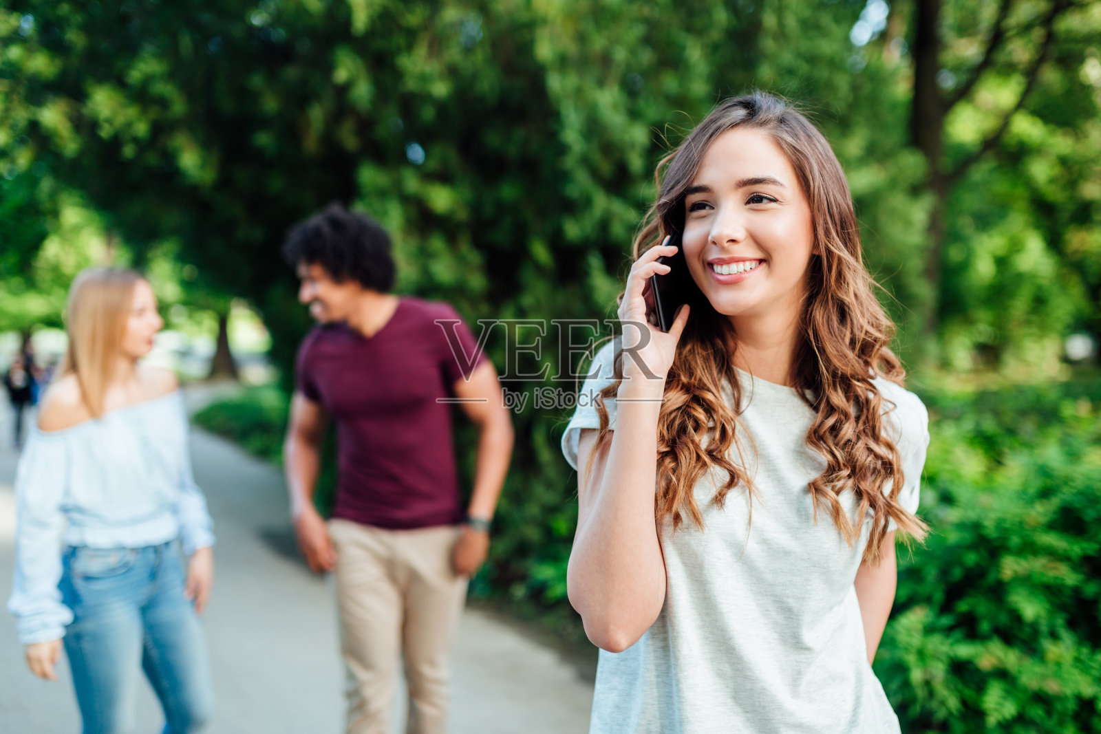 三个朋友在公园里散步照片摄影图片