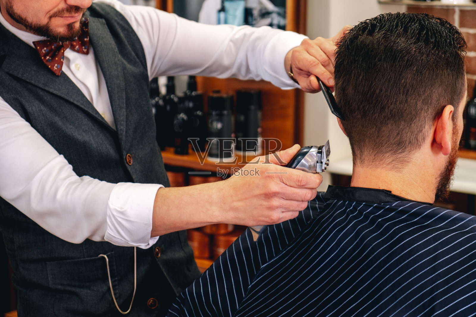 理发师在理发店里照料一位顾客照片摄影图片