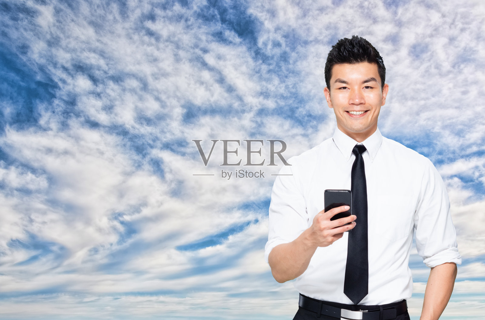 亚洲/中国商人卷起袖子，用手机发短信照片摄影图片