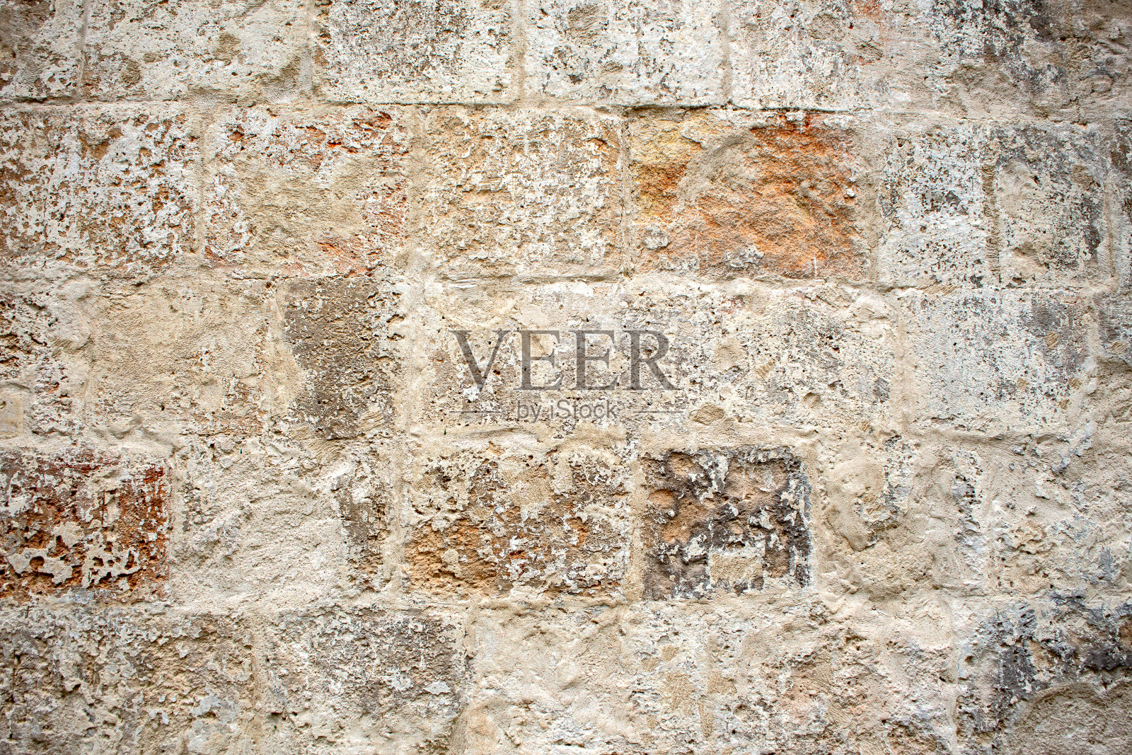 一个破旧的古老的正统修道院砖墙的特写，由大的白色砖块与倒塌的石膏。纹理背景在自然的颜色照片摄影图片