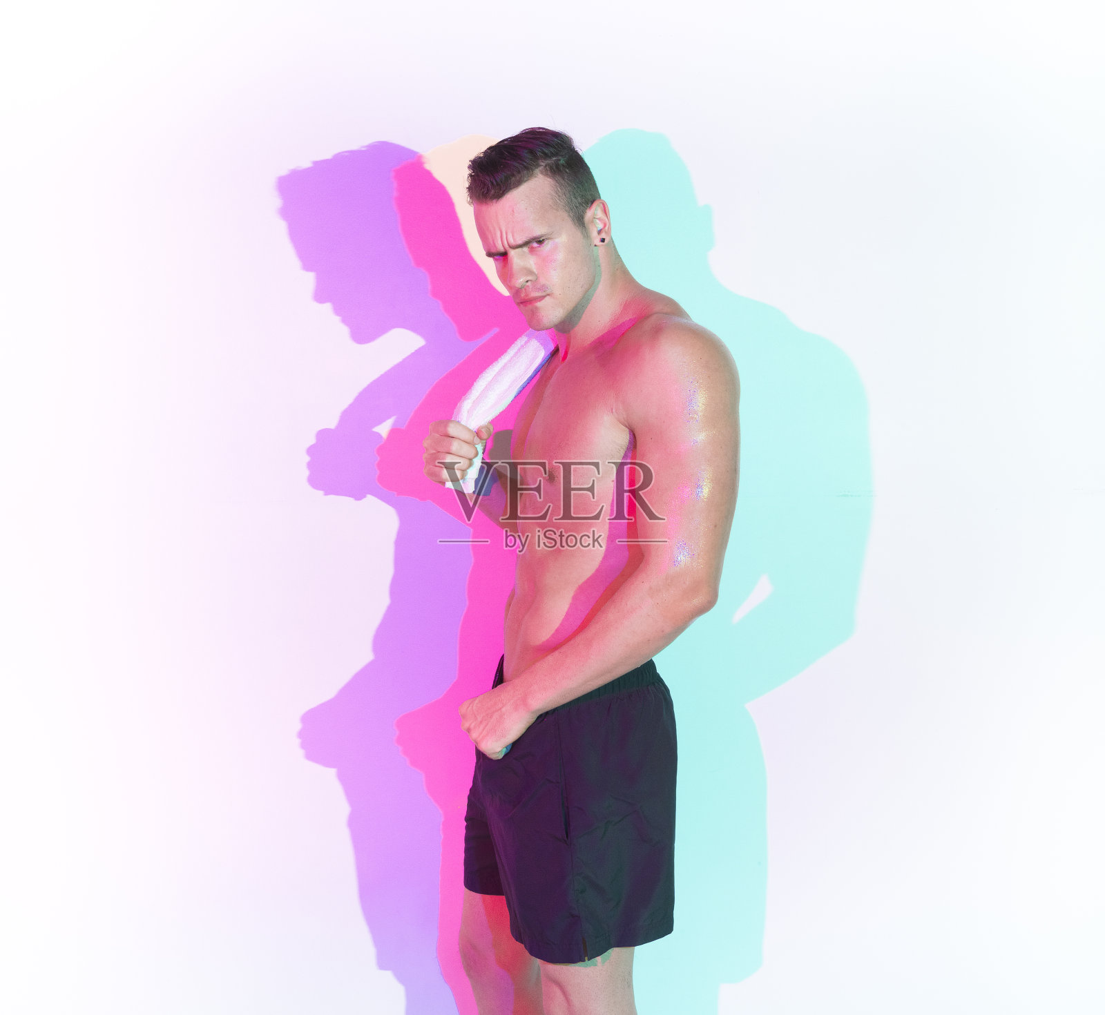 英俊的汗津津的年轻人，他赤膊，拿着一条白毛巾照片摄影图片