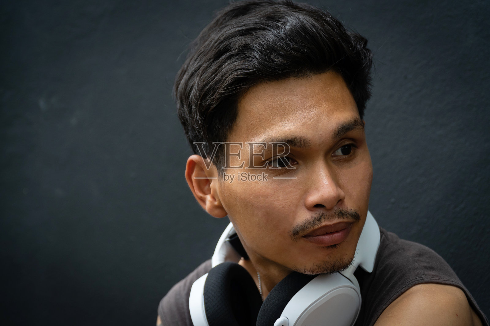 亚裔男子，白色耳机爆头。照片摄影图片