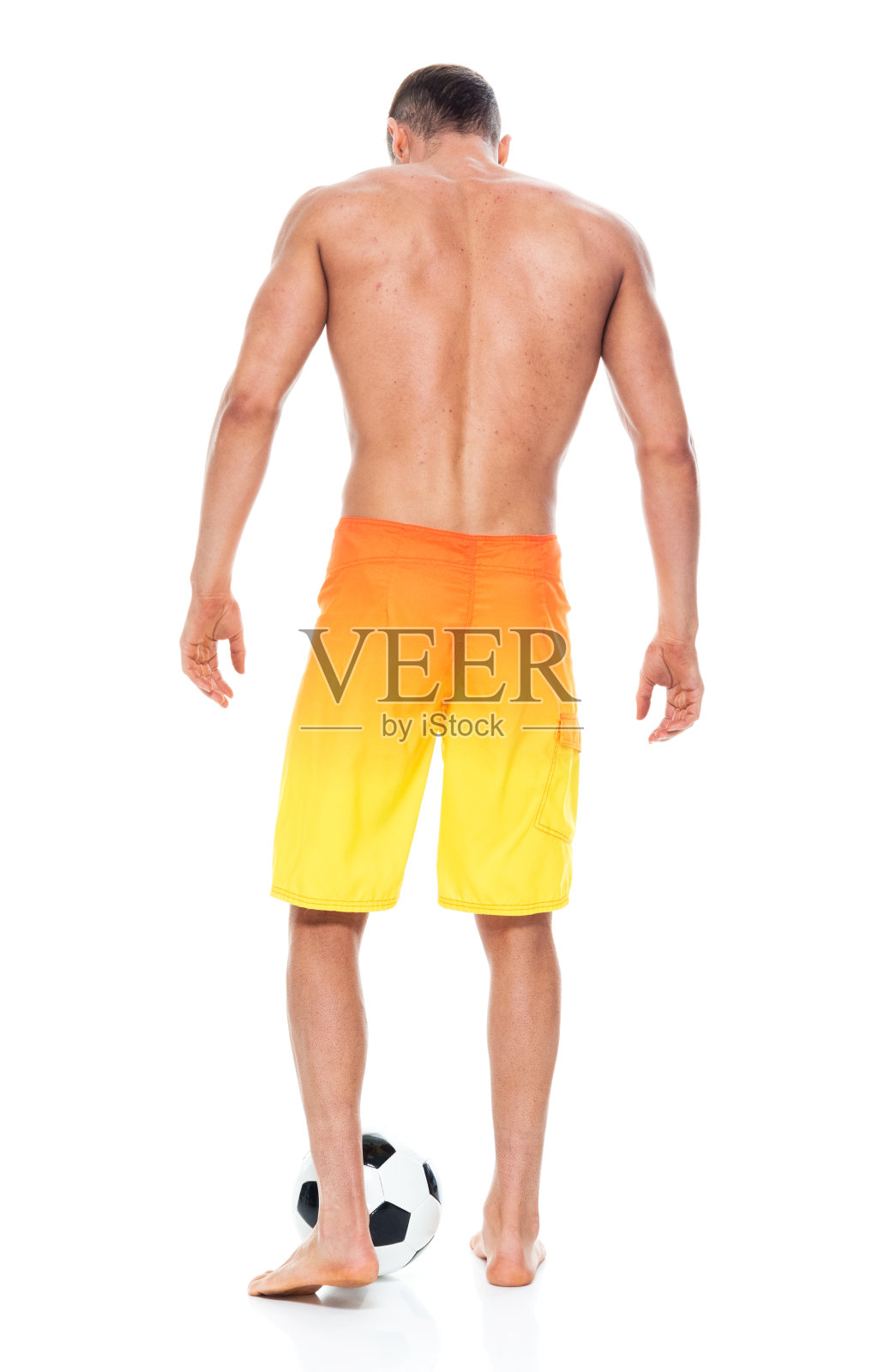 帅气的男人，他赤膊上阵，穿着短裤，还有一个足球照片摄影图片